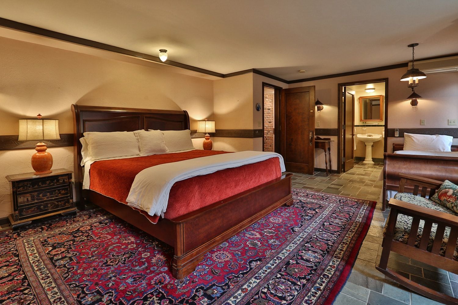 A hotel room with a king size bed and a rug