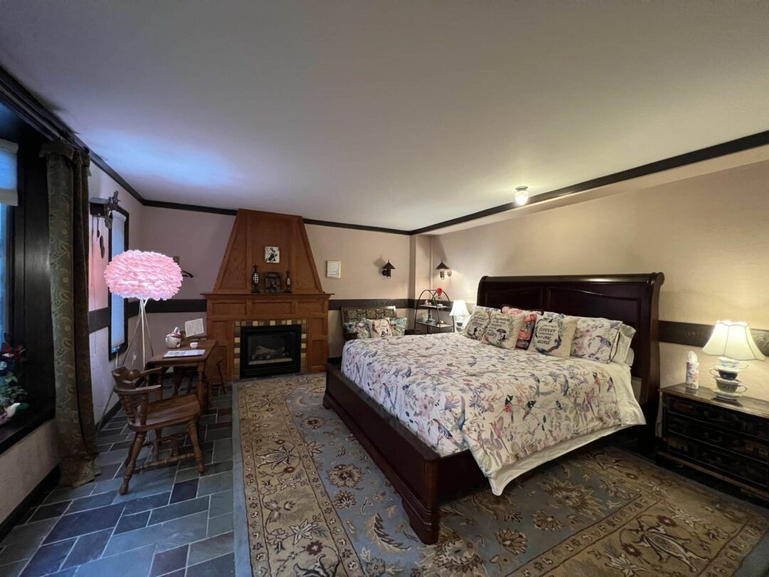 A bedroom with a king size bed and a fireplace.