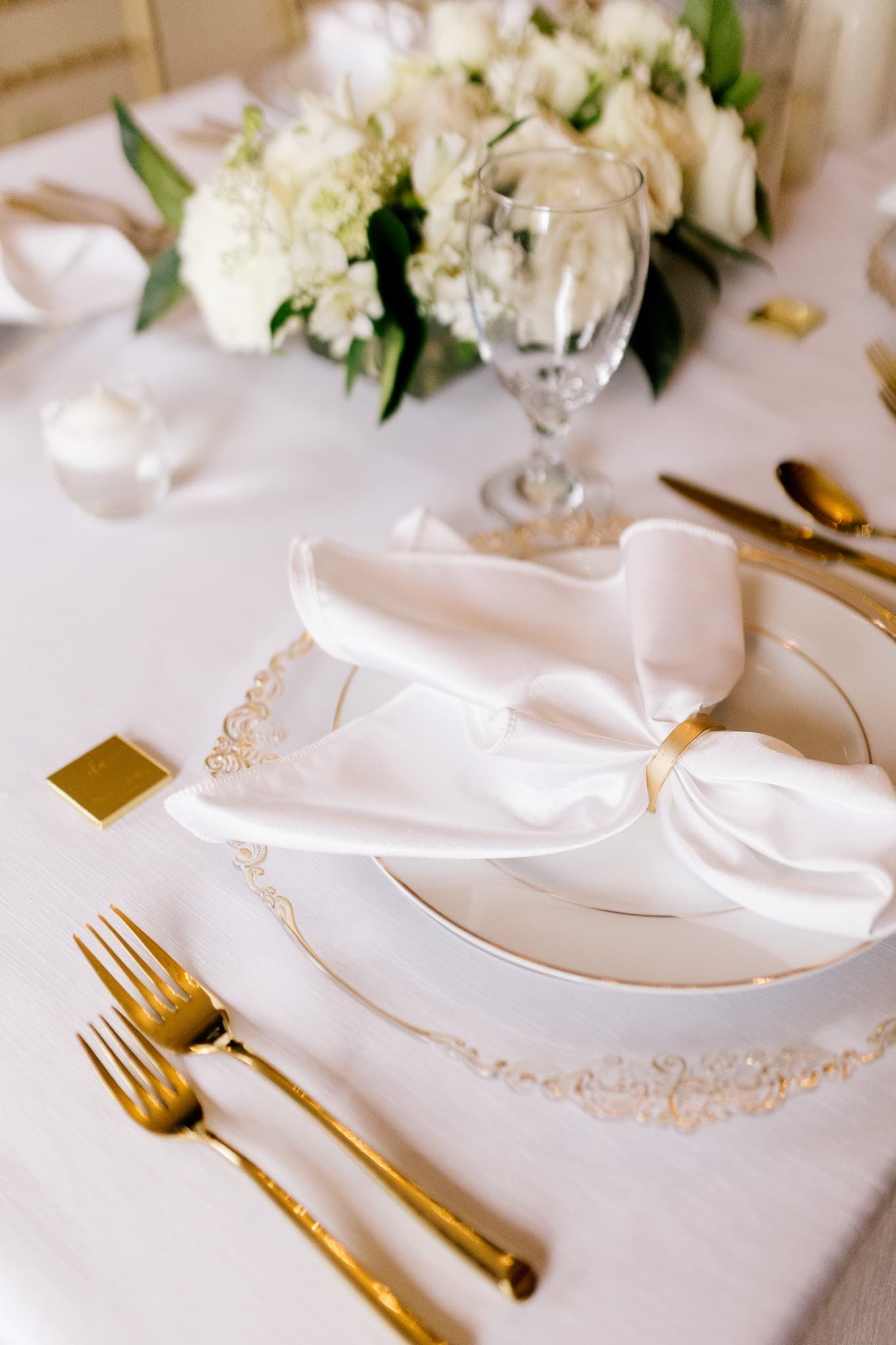A white plate with a napkin ring on it is on a table.