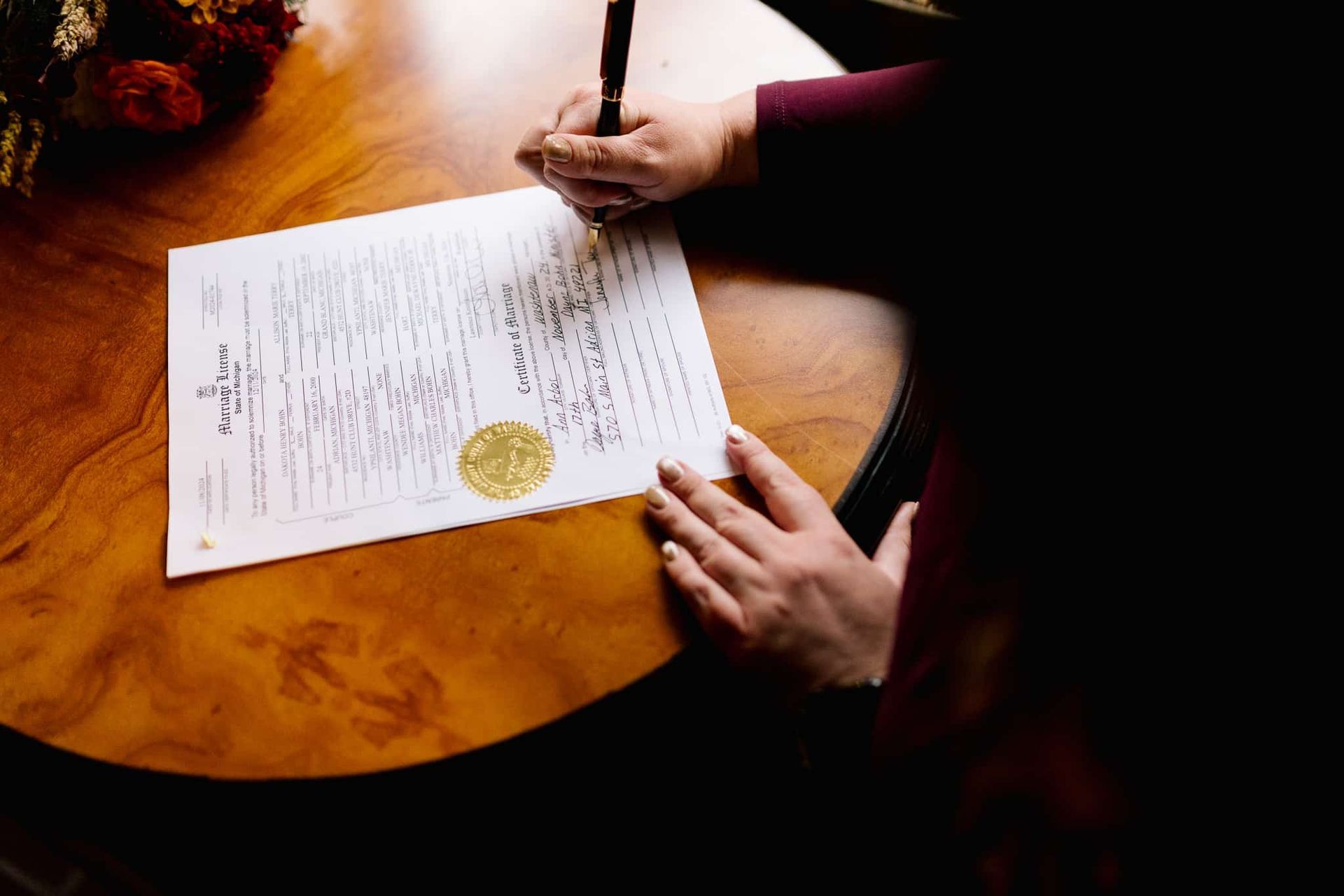 A person is writing on a piece of paper with a pen.