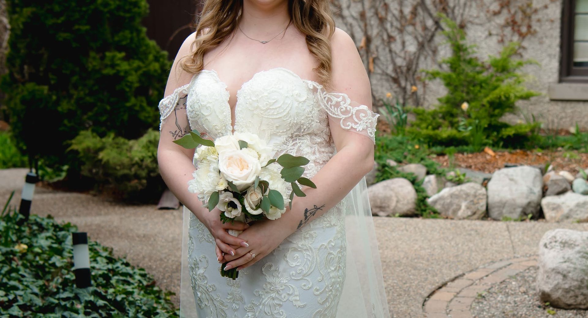 A woman in a wedding dress is holding a bouquet of flowers.