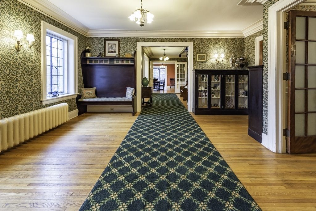 A hallway with a blue carpet and wooden floors