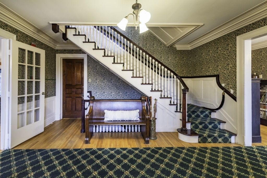 A large hallway with a staircase and a bench