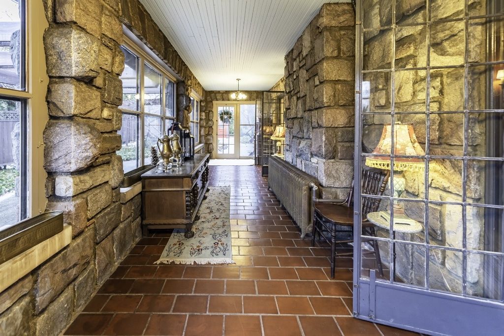 A long hallway with brick walls and tile floors in a house.