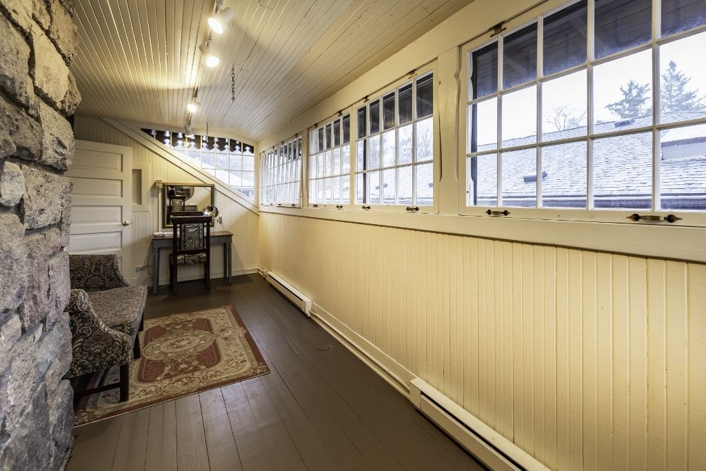 A long hallway in a house with lots of windows