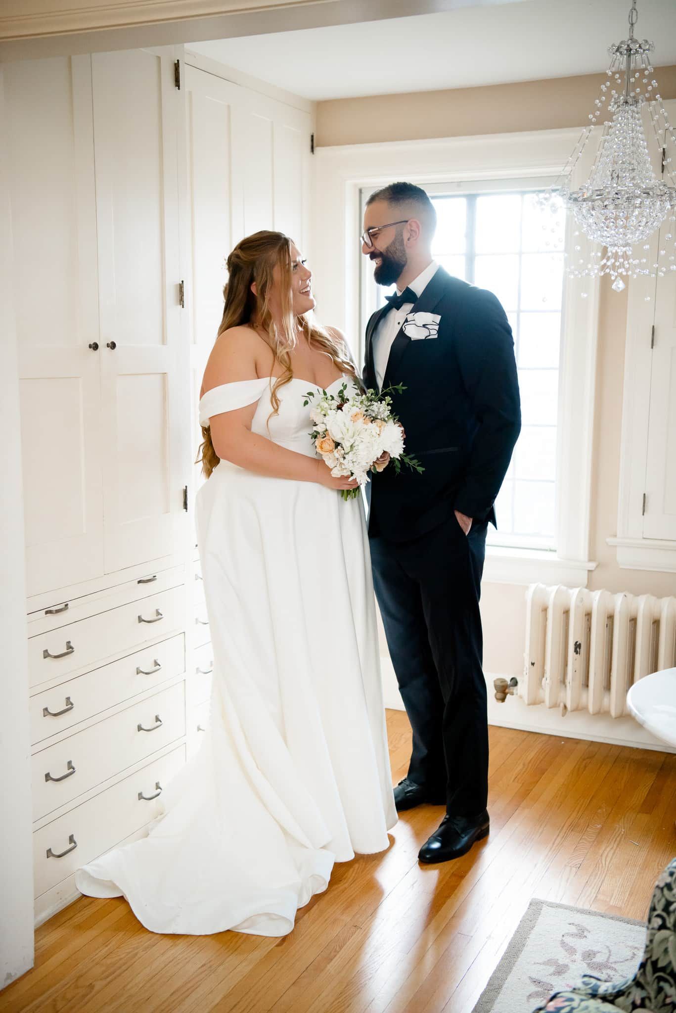 A bride and groom are standing next to each other in a room.