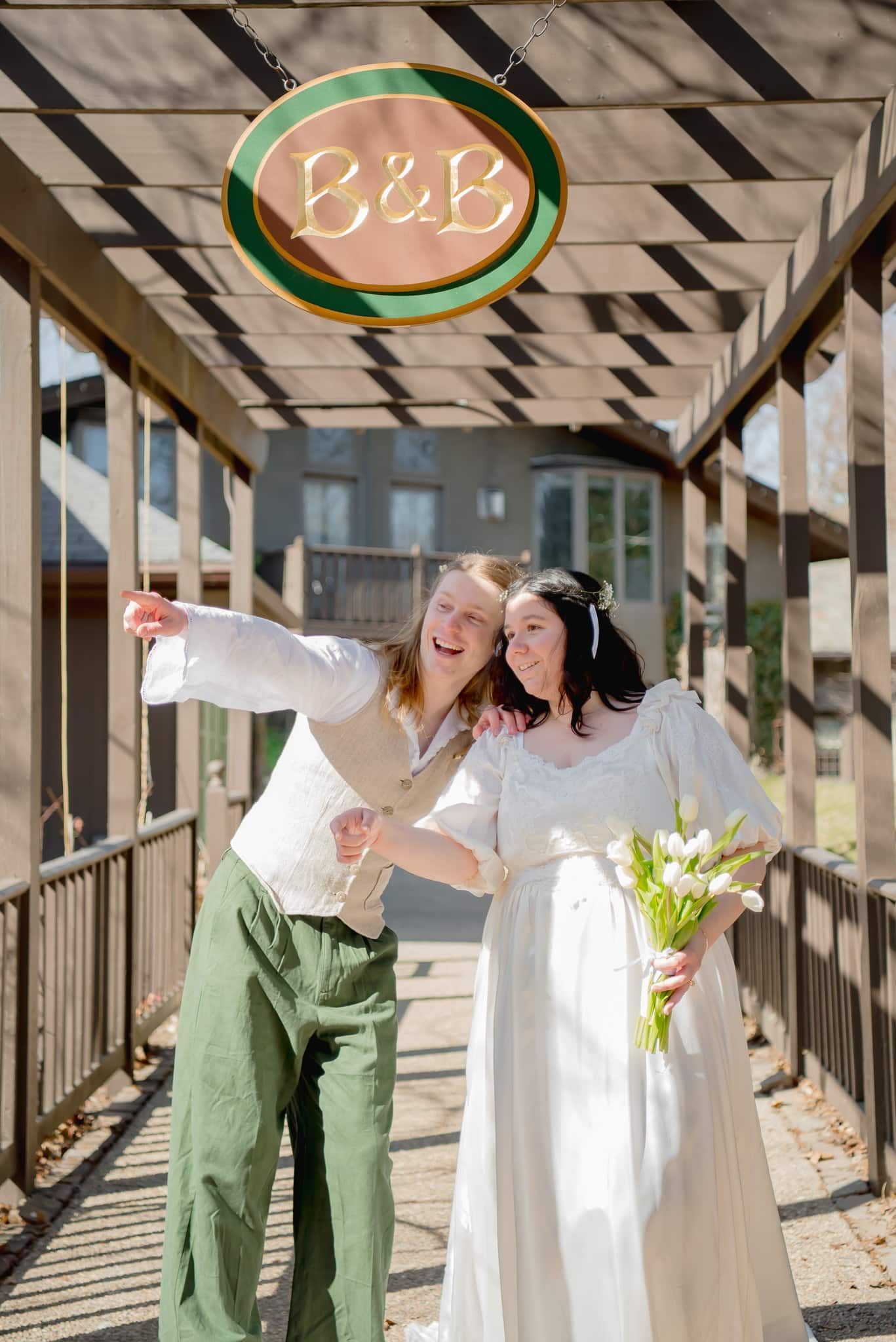 A bride and groom are posing for a picture under a pergola.