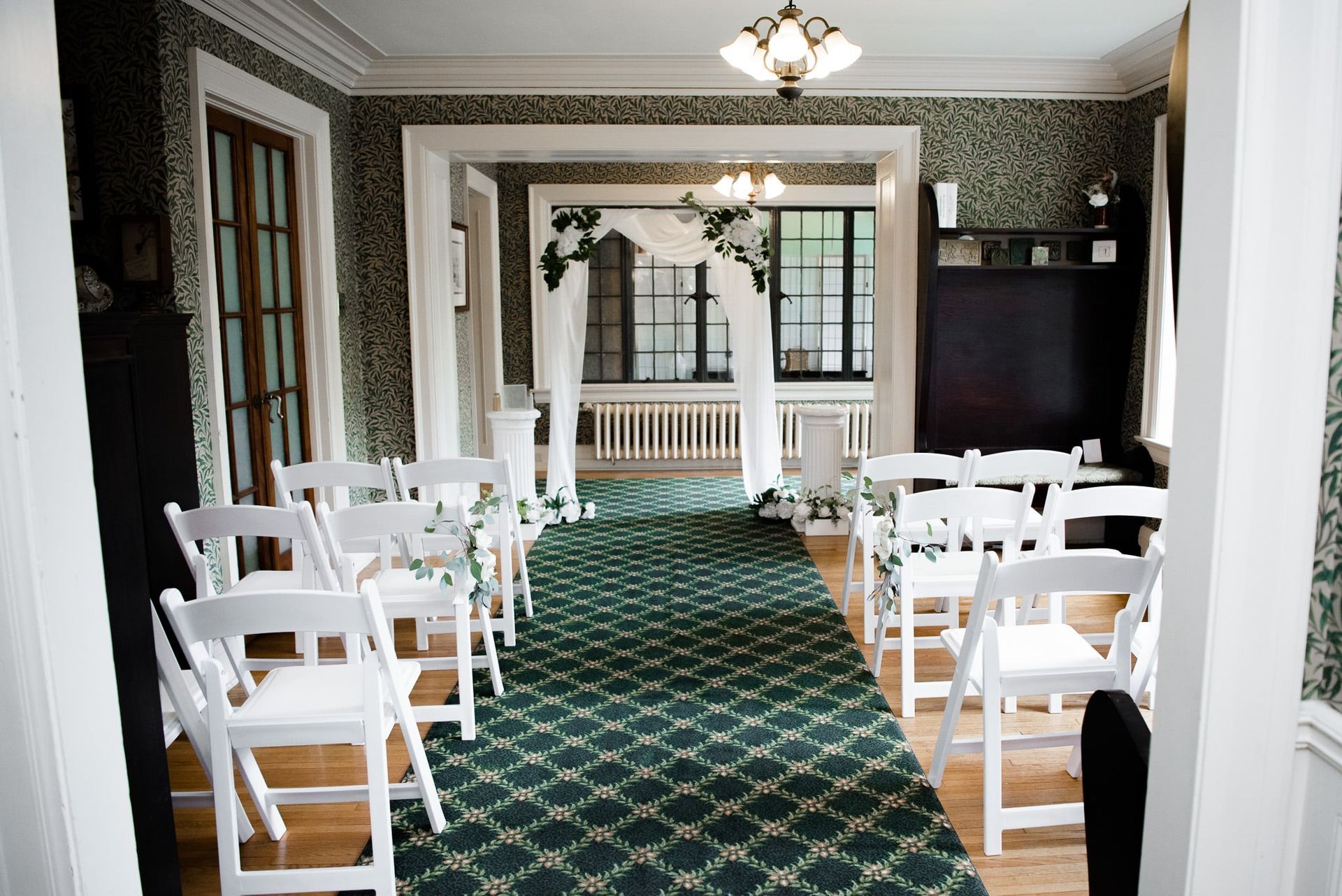 A room with white chairs and a green carpet