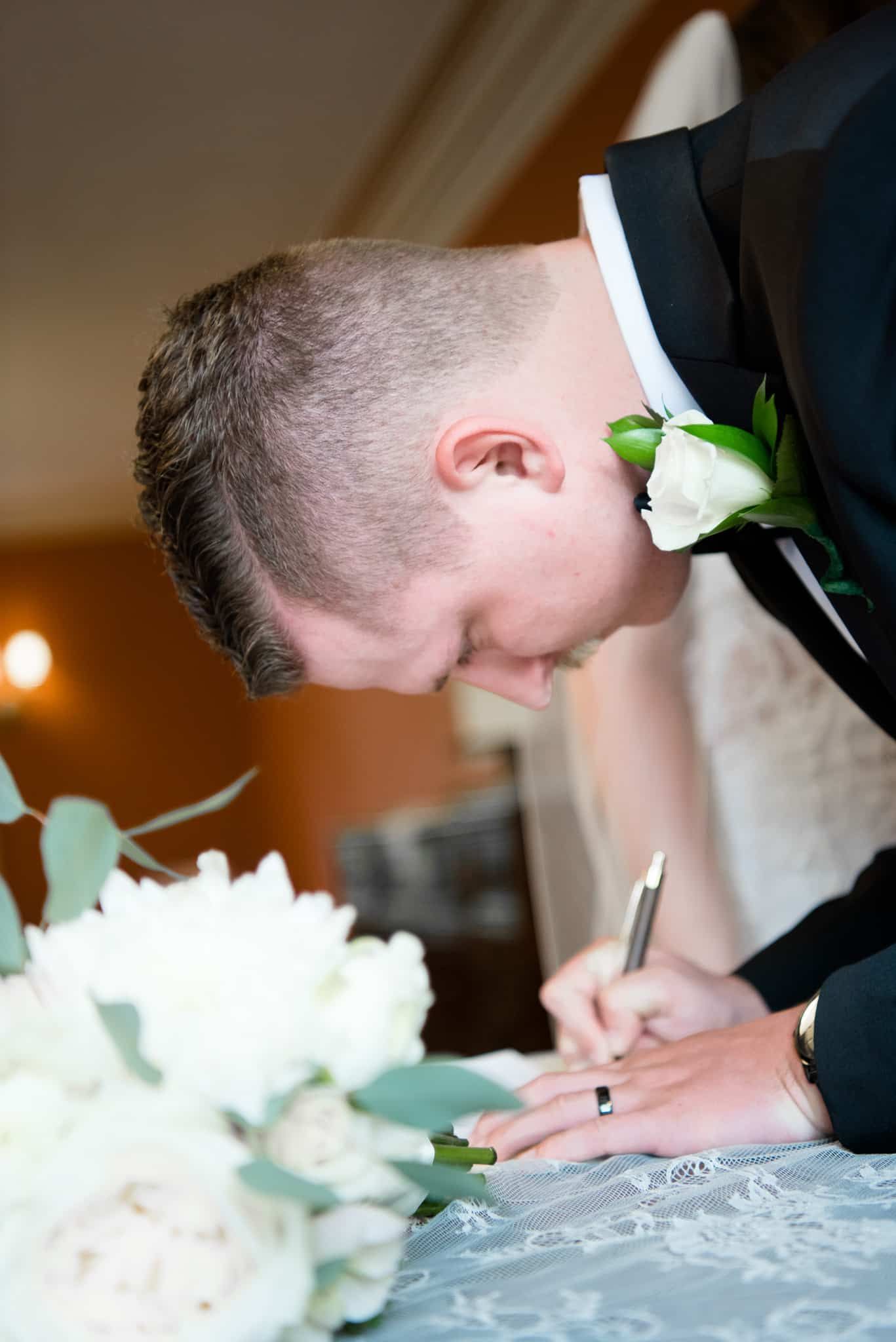 A bride and groom are signing their wedding papers.