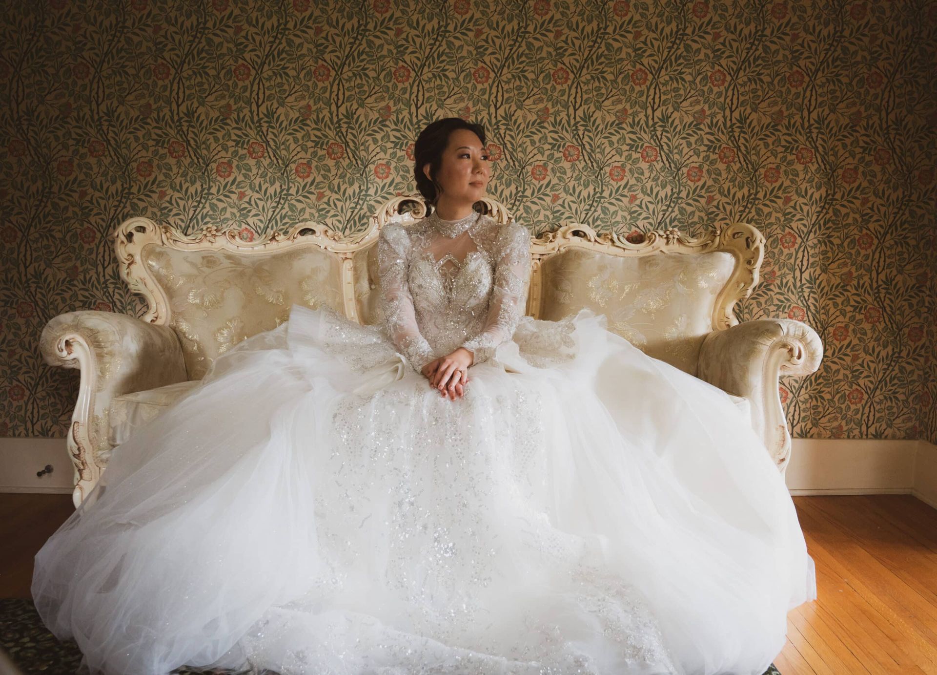 A woman in a wedding dress is sitting on a couch.