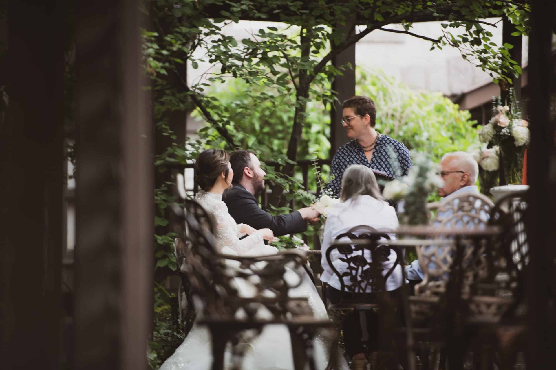 A bride and groom are sitting at a table with their family.