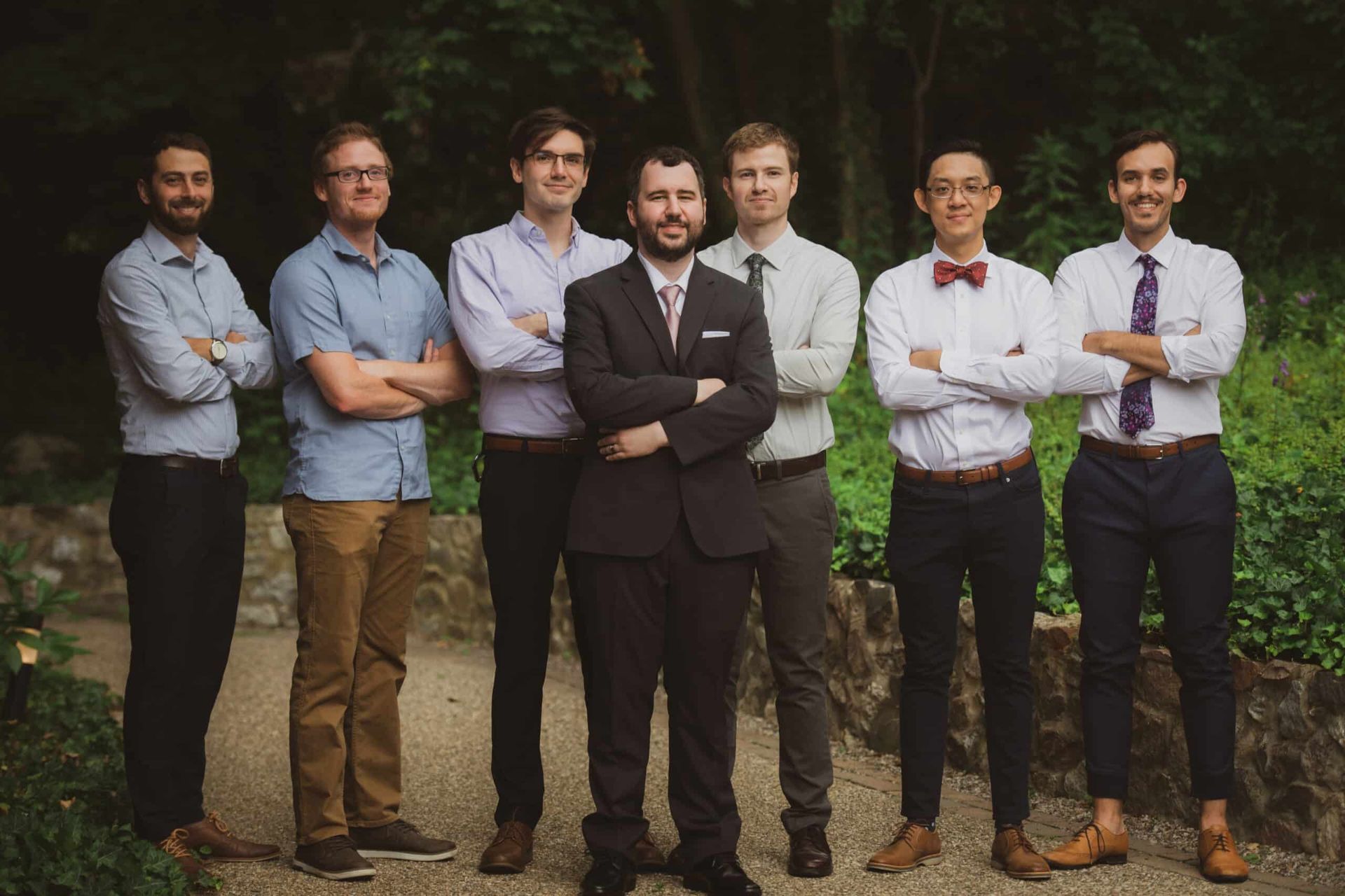 A group of men standing next to each other with their arms crossed.