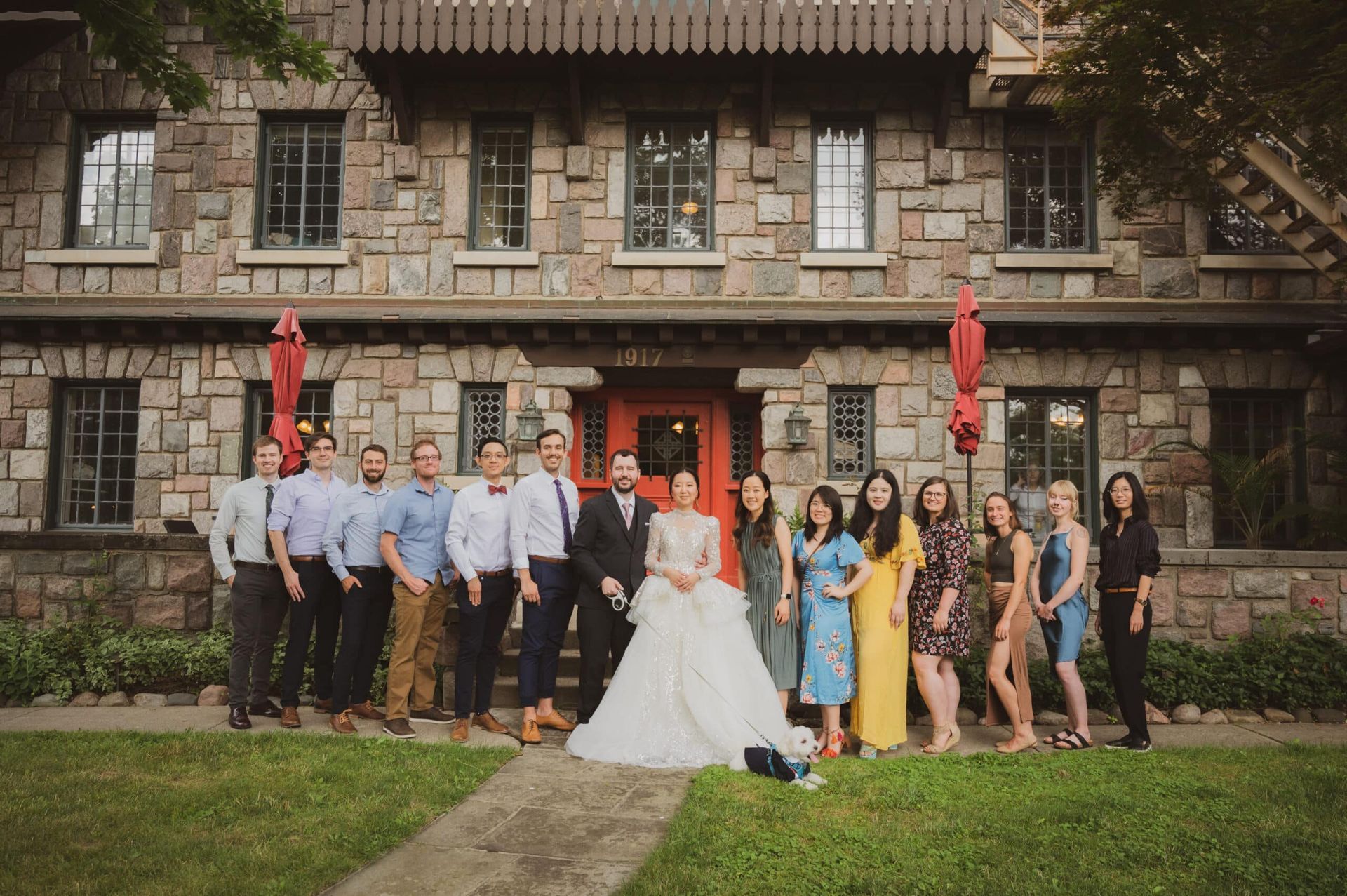 A group of people are posing for a picture in front of a stone building.