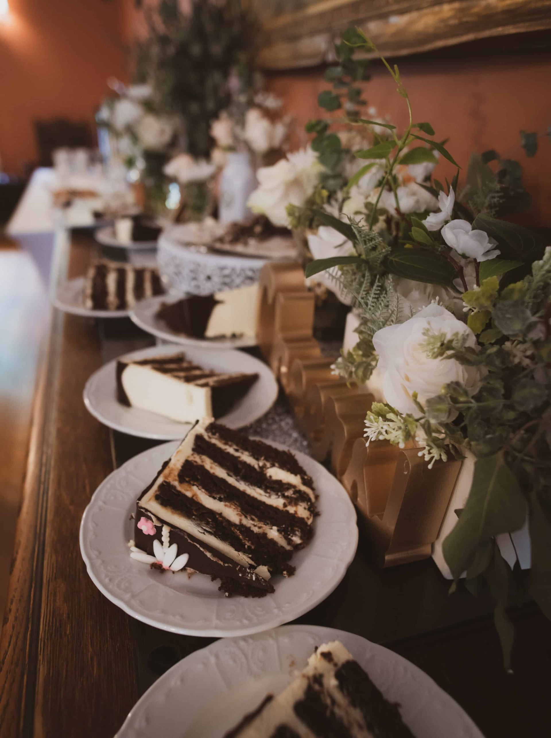 A table with plates of cake and flowers on it