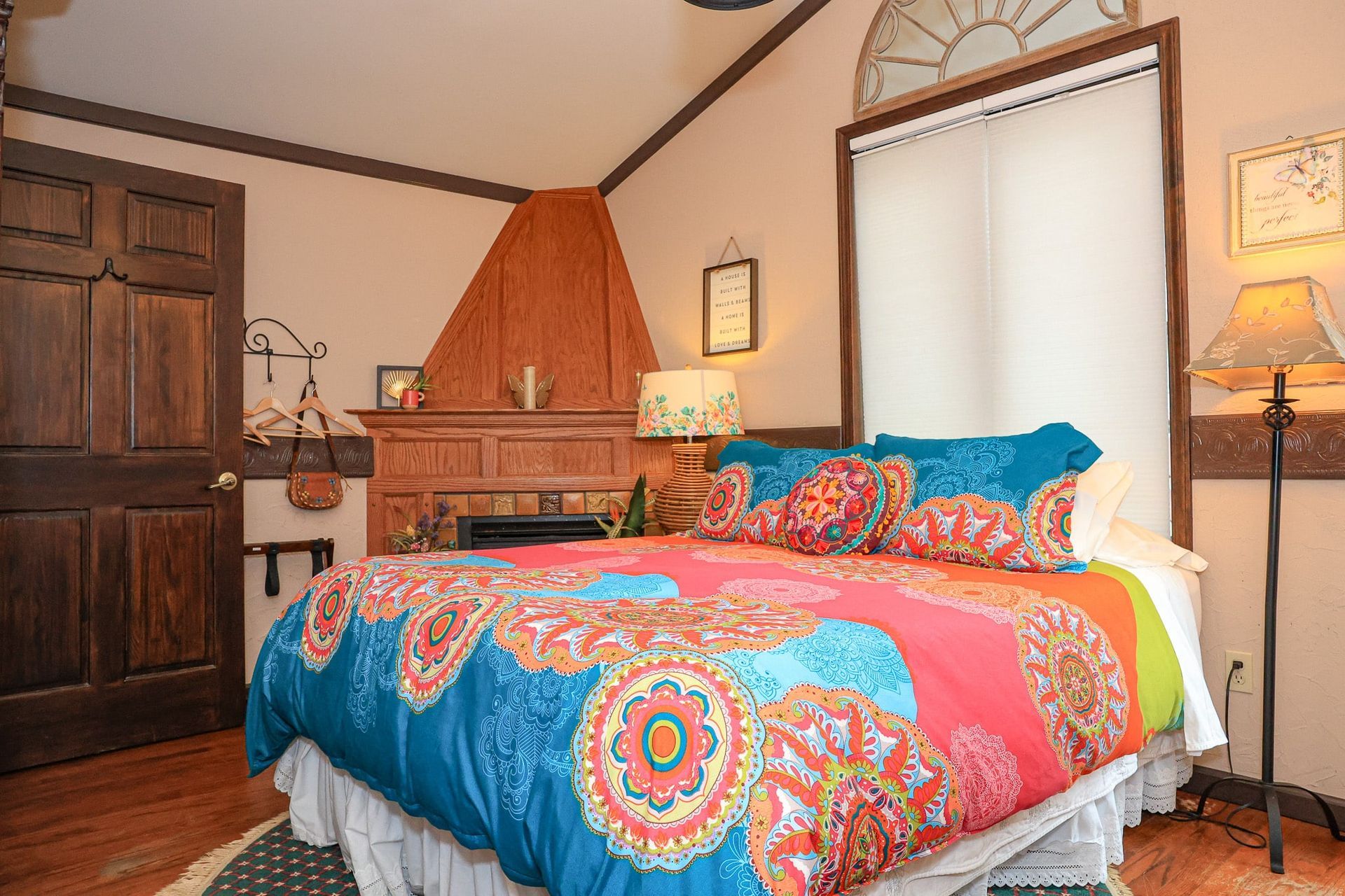 A bedroom with a king size bed and a fireplace.