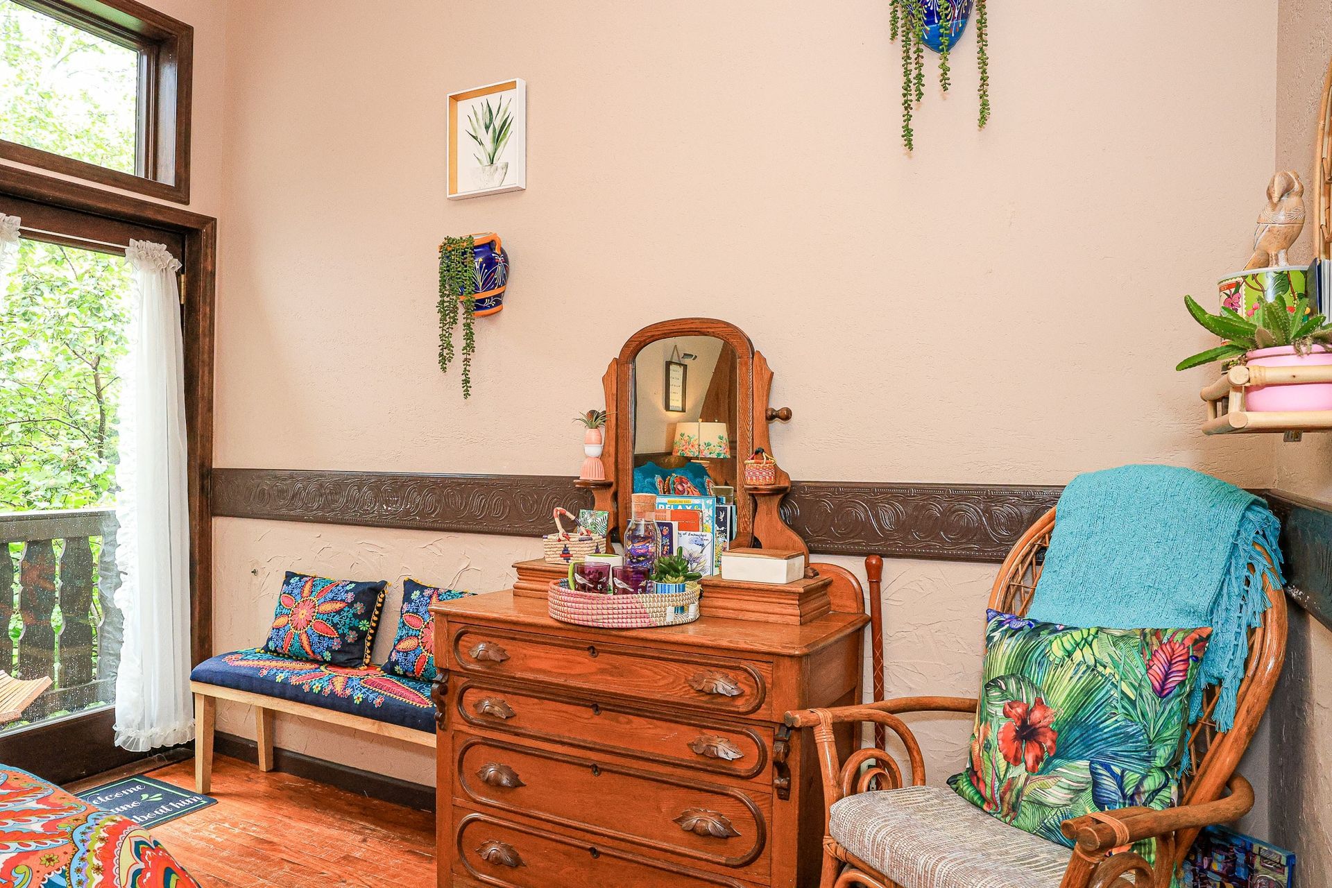 A bedroom with a dresser , chair , and mirror.