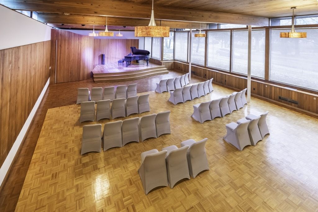 A large room with rows of chairs and a piano