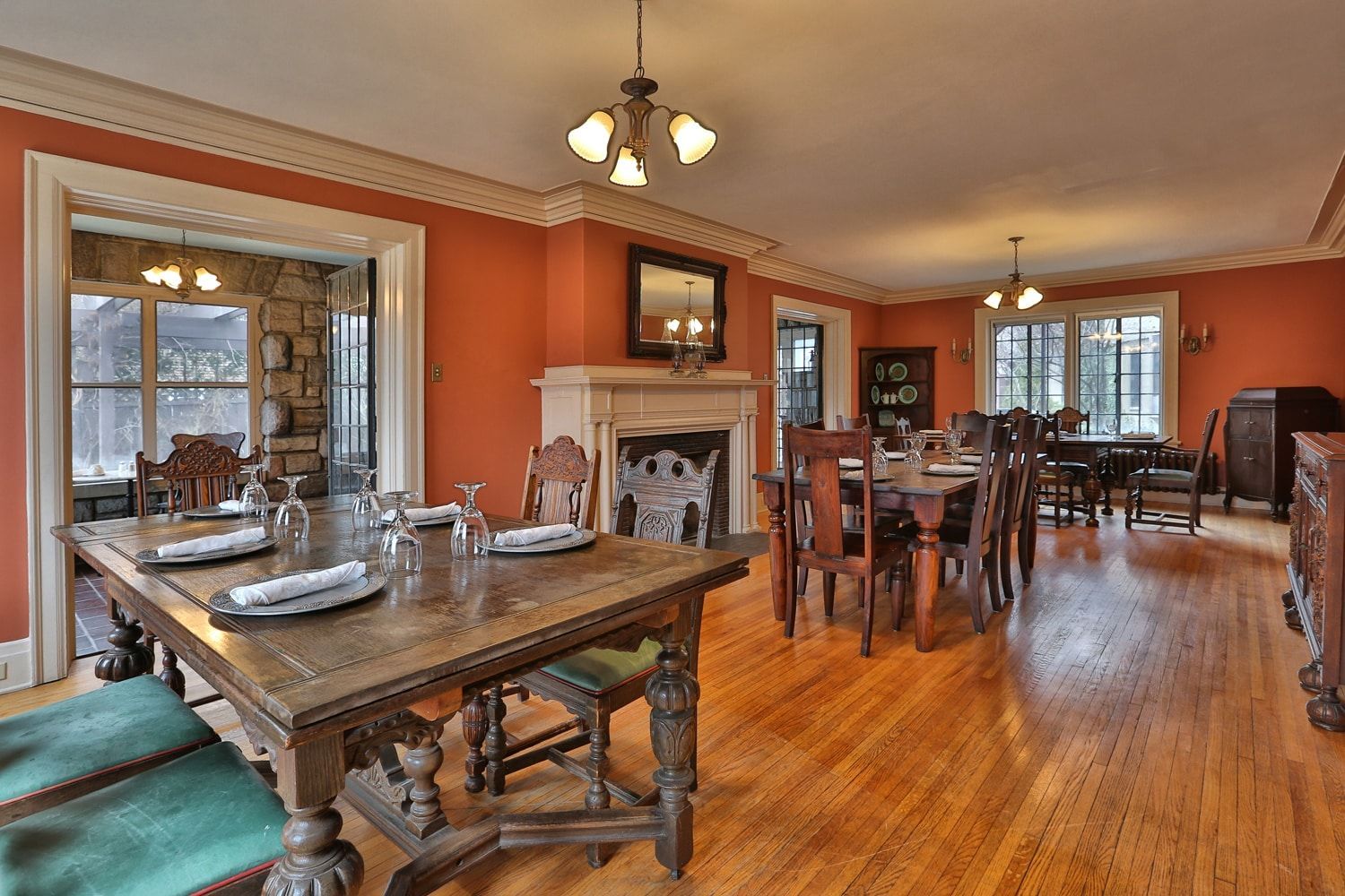 A large dining room with tables and chairs and a fireplace.