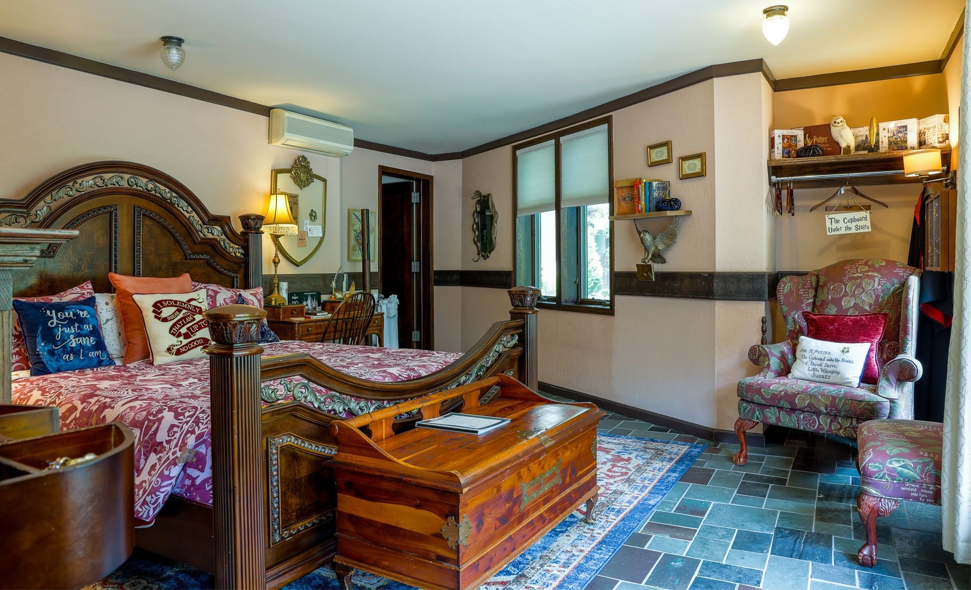 A bedroom with two beds , a chair , and a trunk.