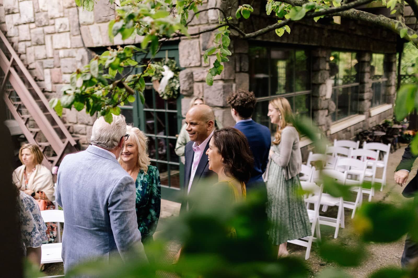A group of people are standing outside of a building talking to each other.
