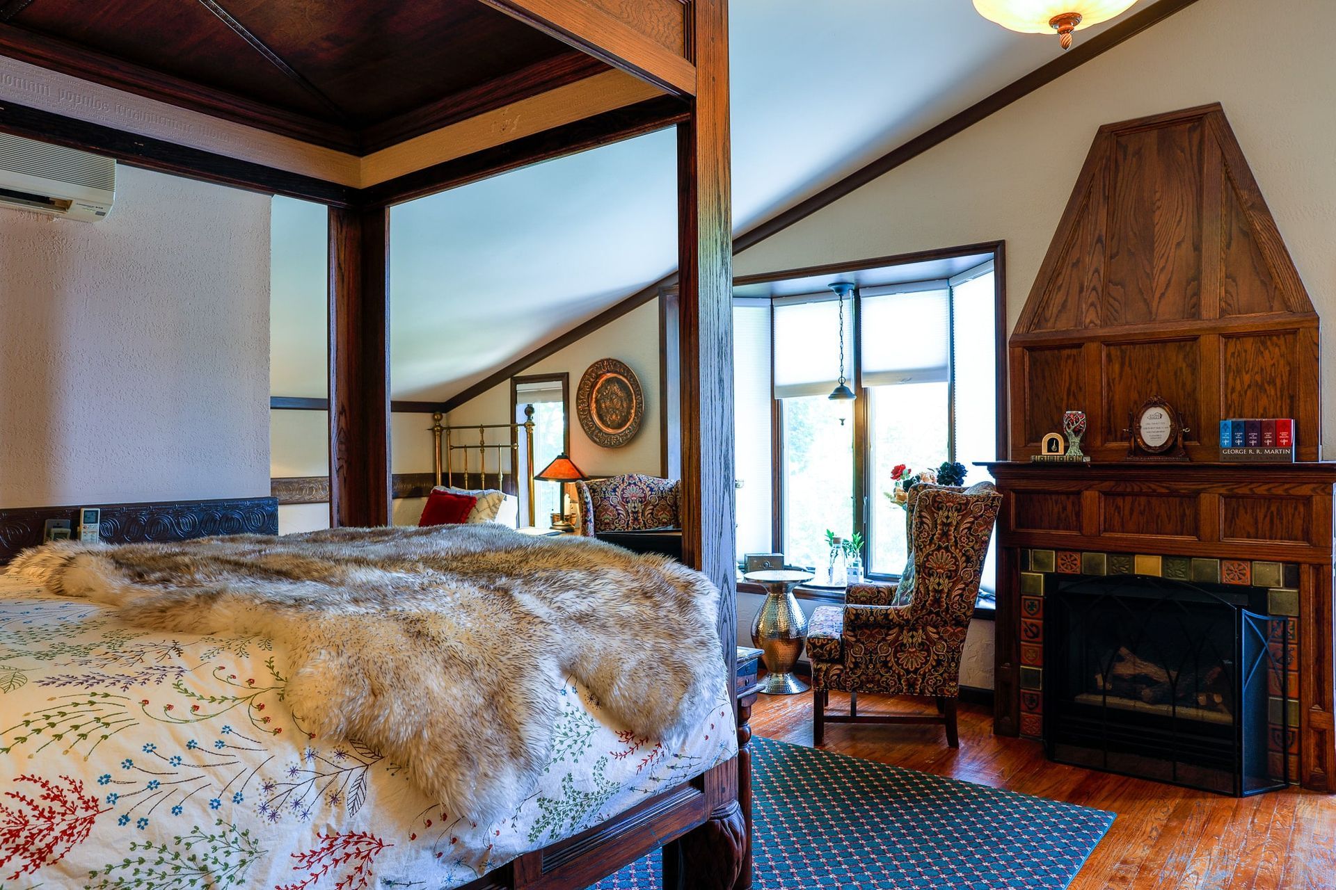 A bedroom with a four poster bed and a fireplace
