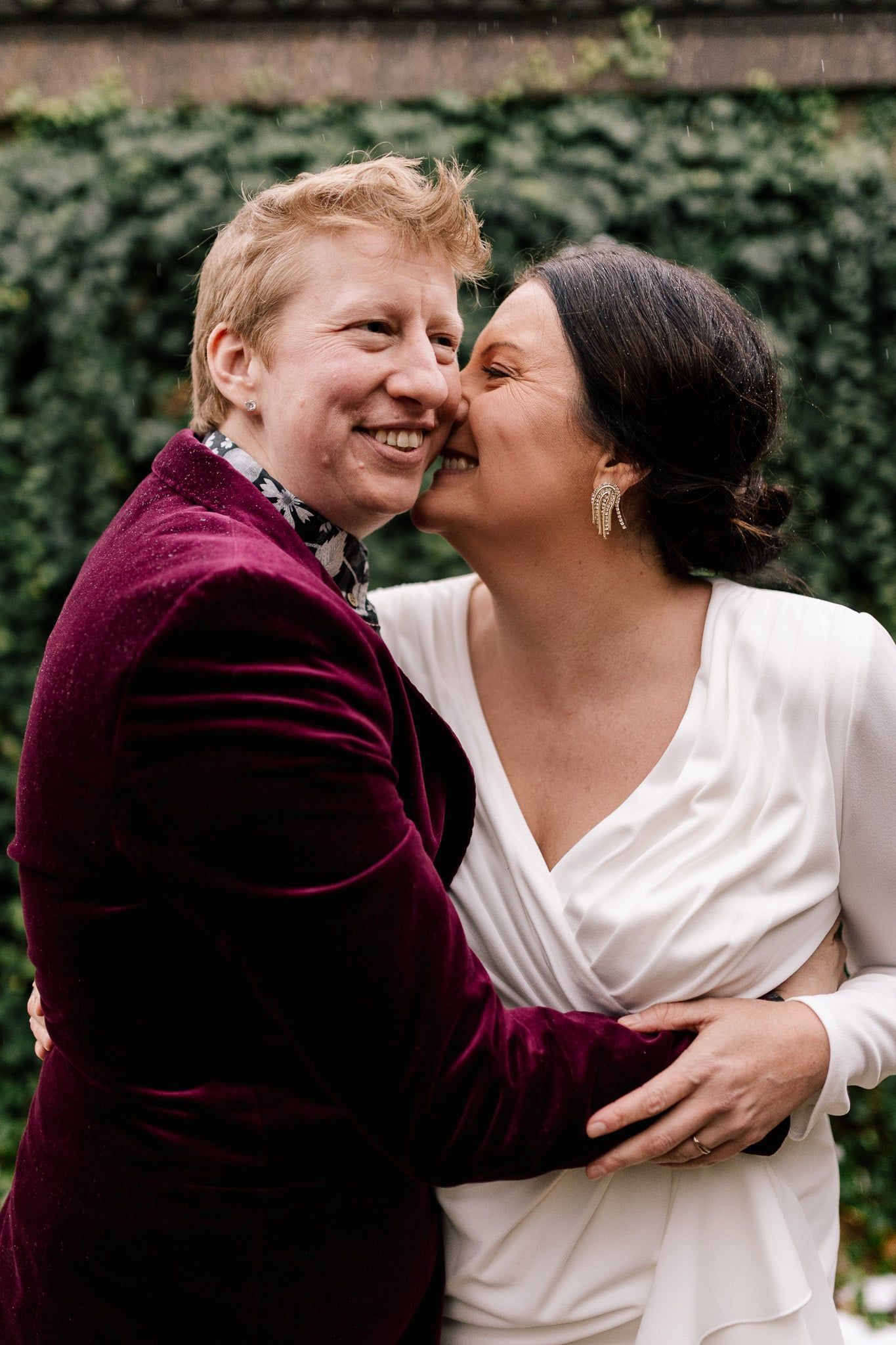 A man in a purple suit is kissing a woman on the cheek.