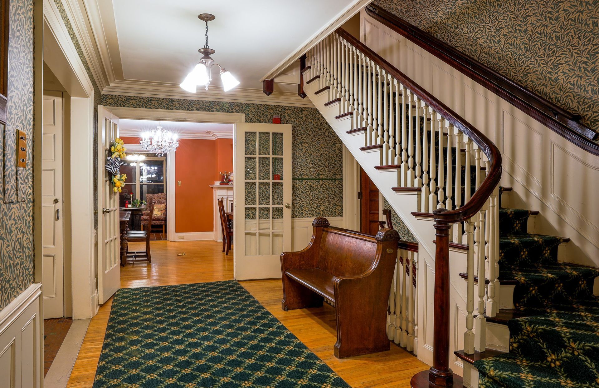 A hallway with a bench and stairs in a house