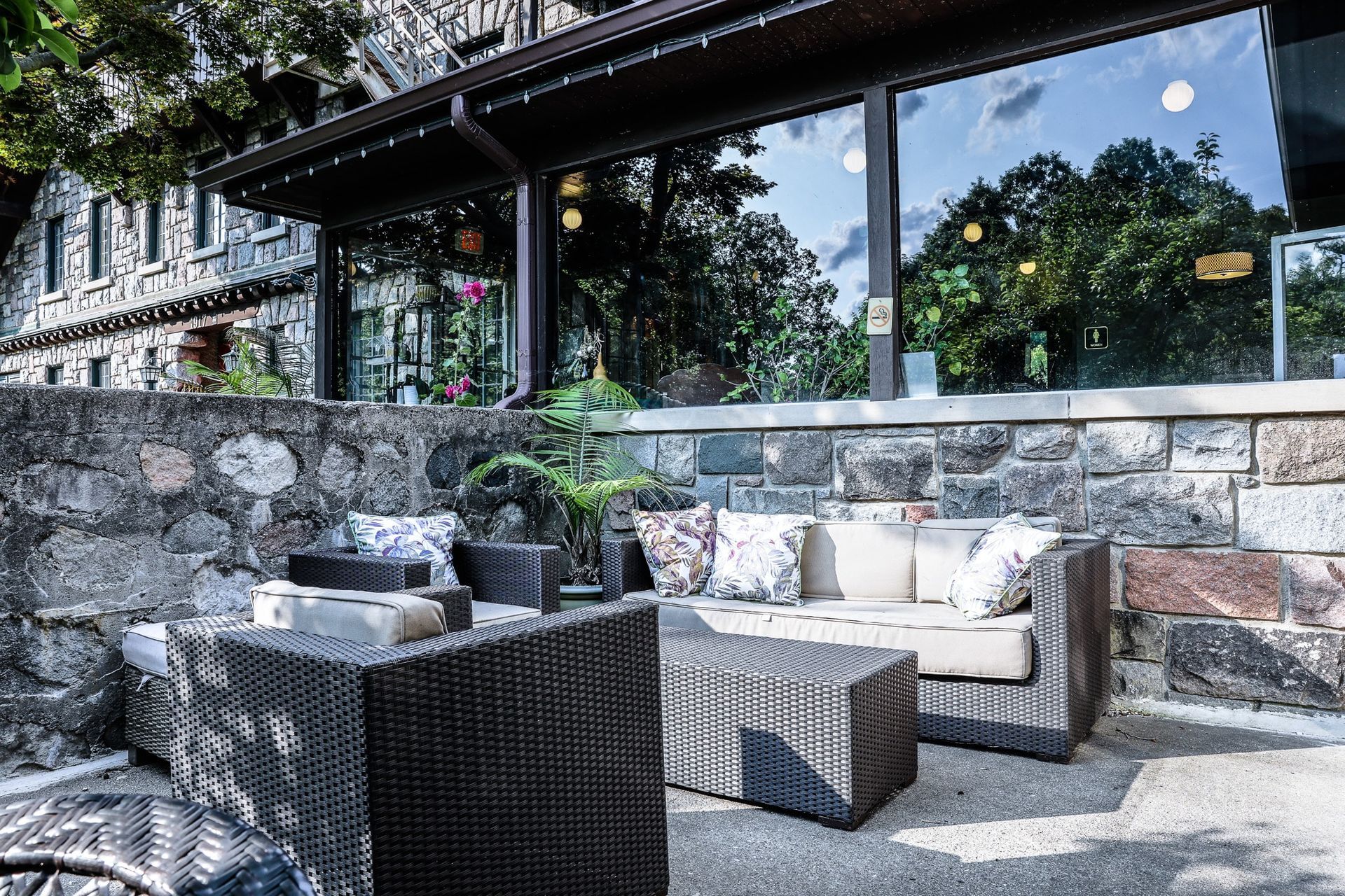 A patio with a couch and chairs in front of a building.