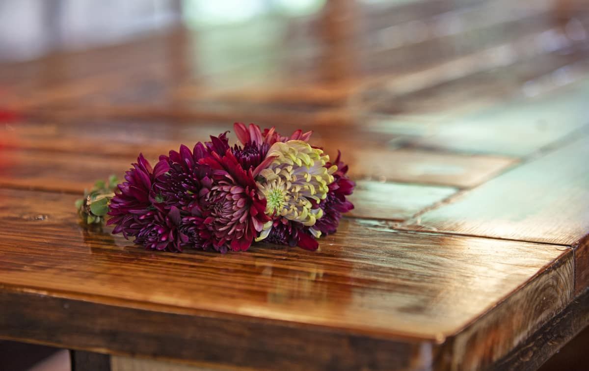 A bouquet of flowers is sitting on a wooden table.