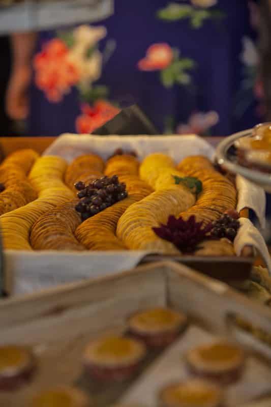 A tray of croissants with grapes on top of them on a table.