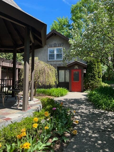A house with a red door and a gazebo in front of it