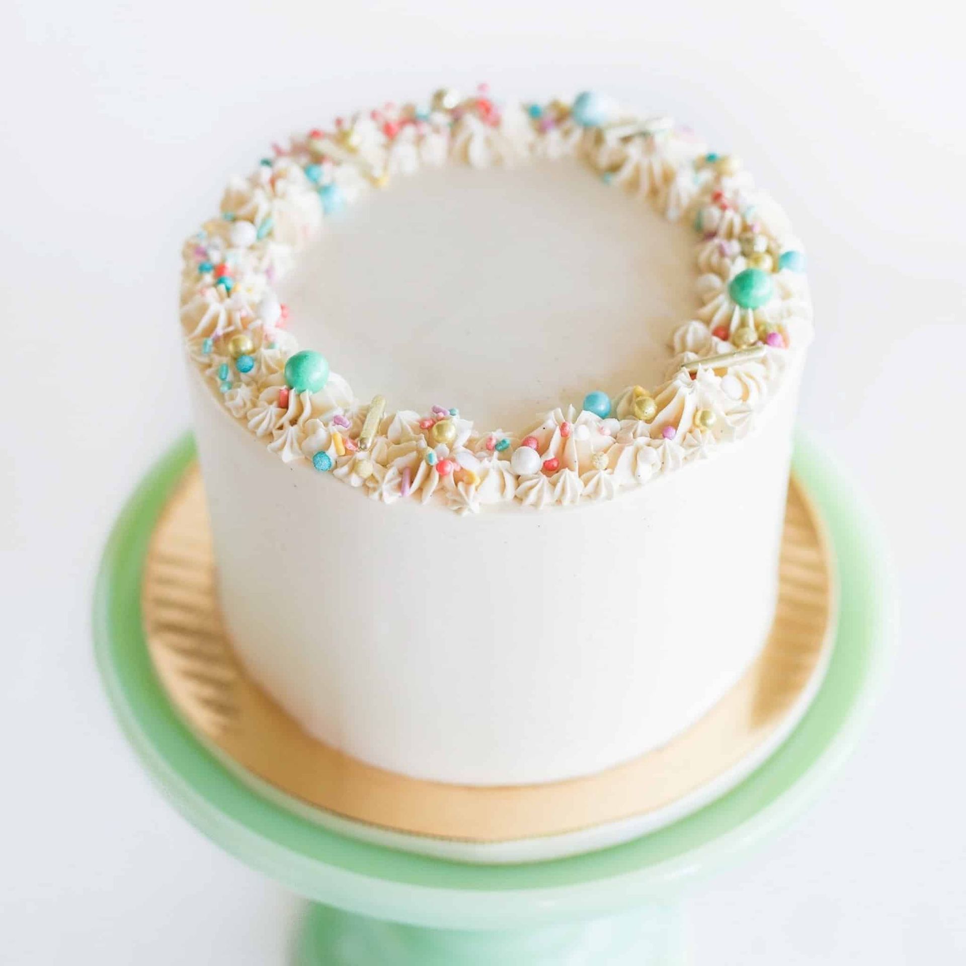 A bride and groom are posing for a picture while the bride is holding a bouquet of red flowers.