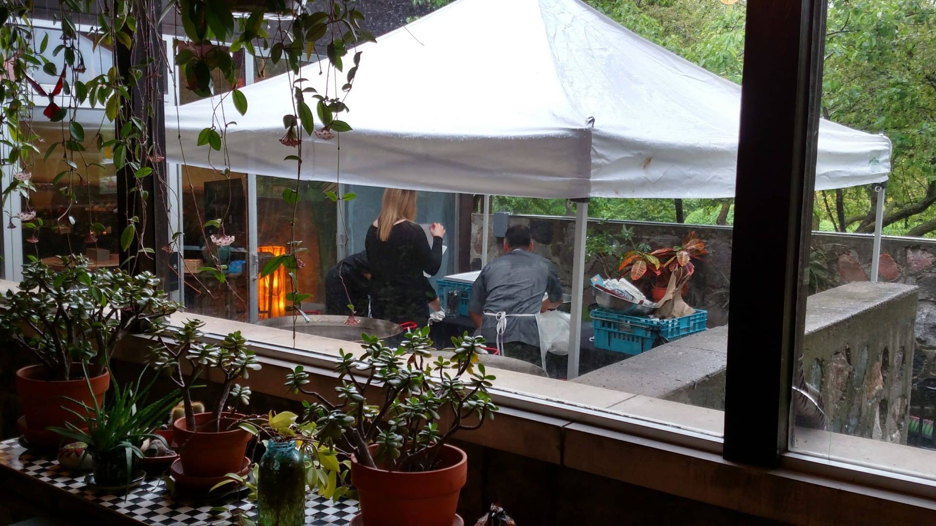 A group of people are sitting under a white tent.