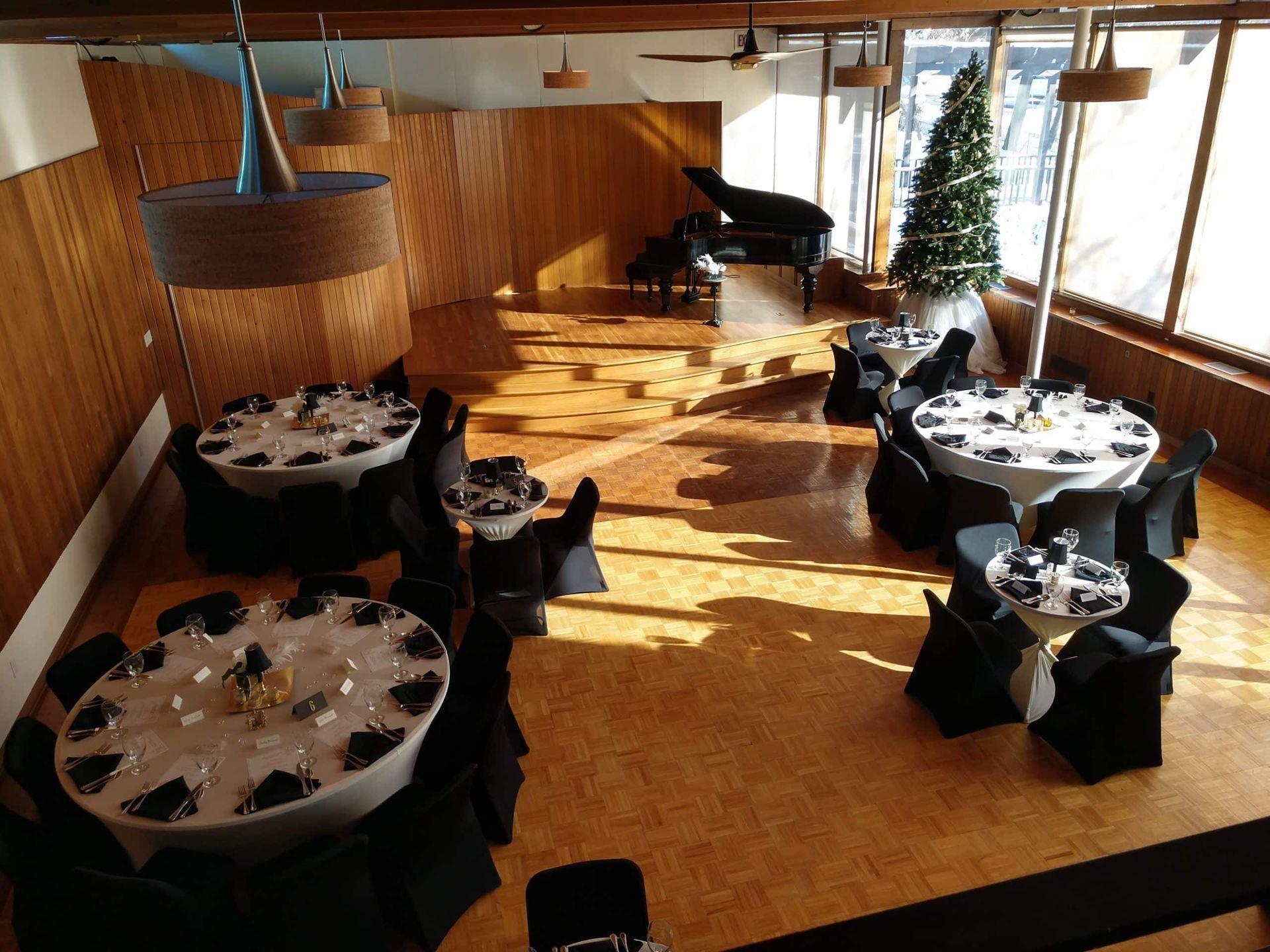 A large room with tables and chairs and a piano