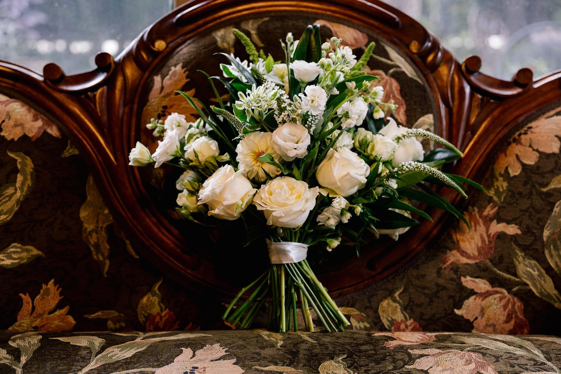 A bouquet of white flowers is sitting on a couch.