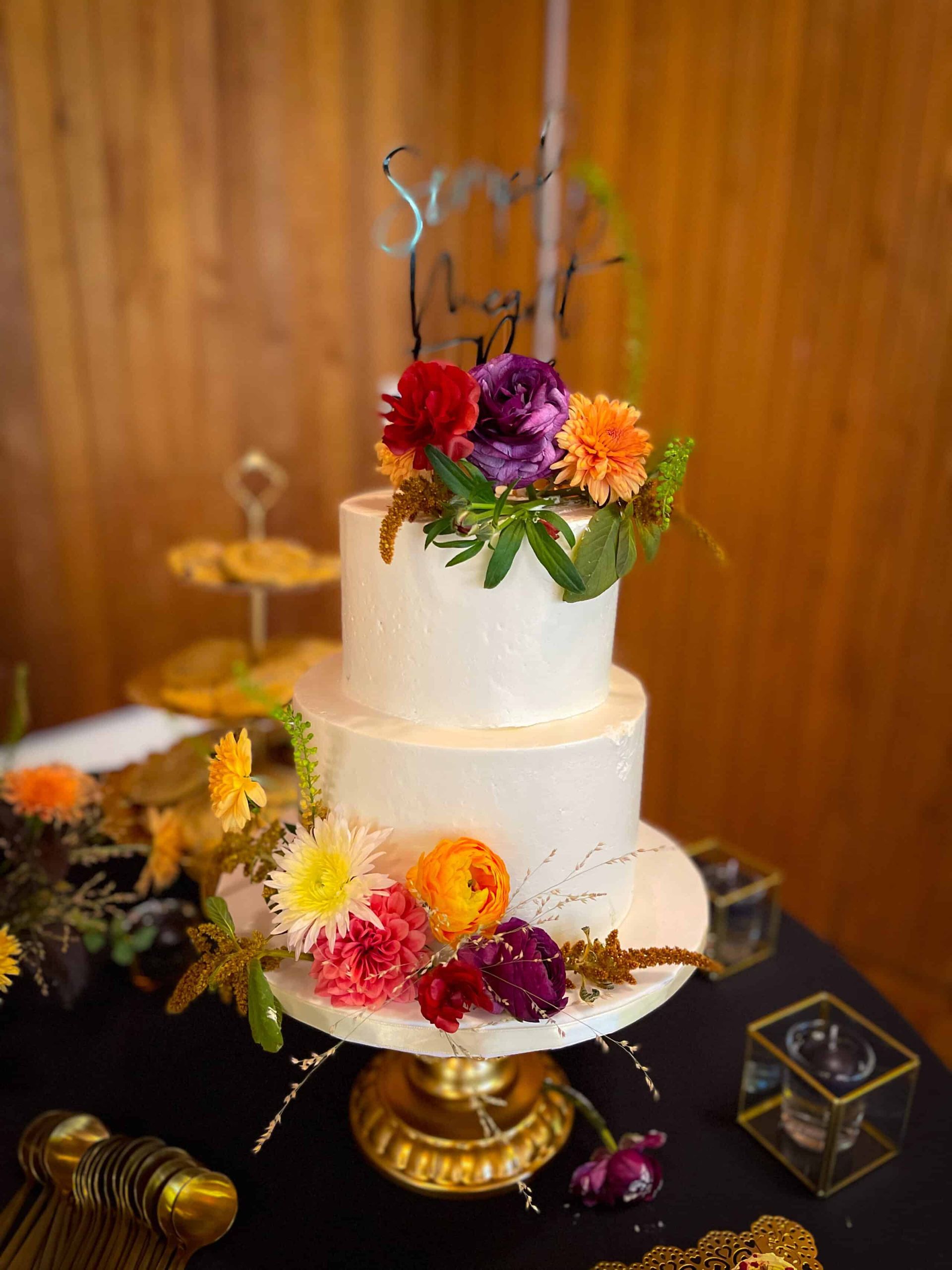 A bouquet of flowers with a pink ribbon is hanging on a wall.