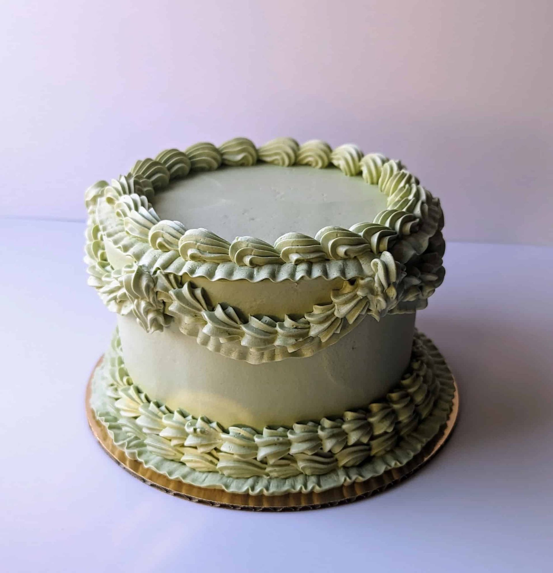 A bouquet of flowers with a pink ribbon is hanging on a wall.