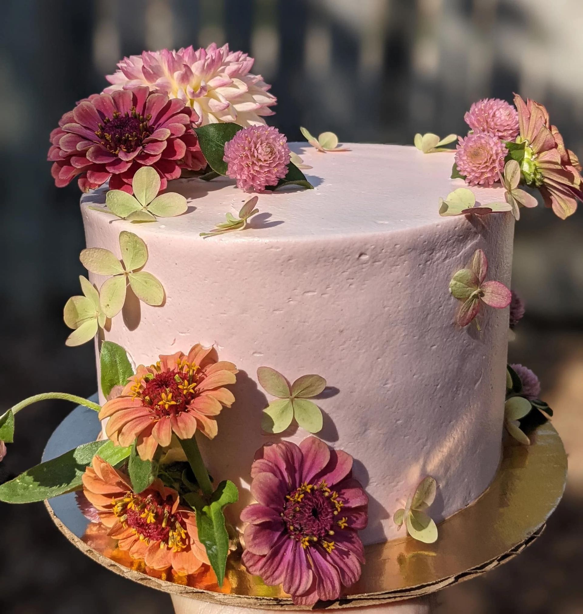 A woman in a white dress is holding a bouquet of pink and white flowers