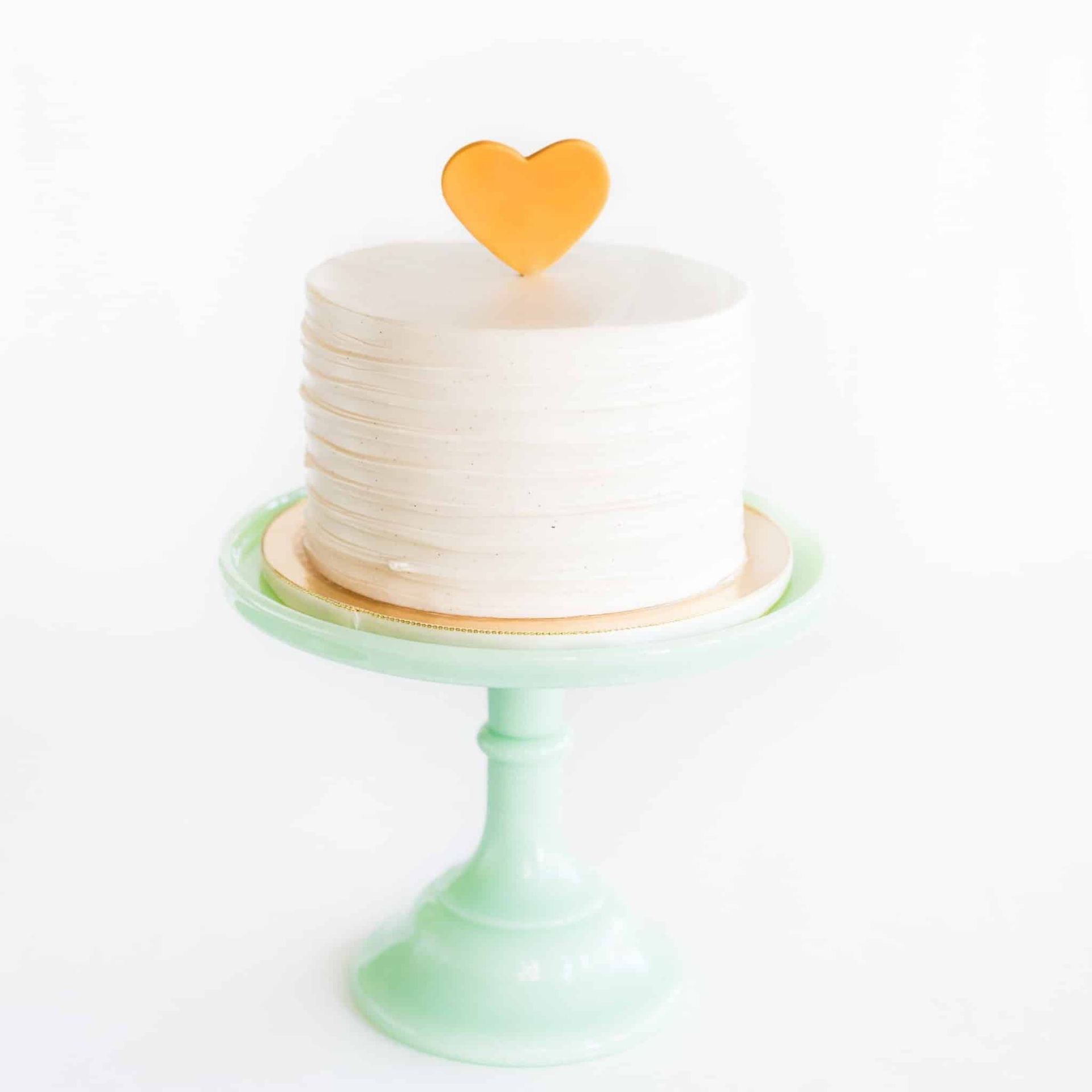 A bouquet of flowers with a pink ribbon is hanging on a wall.