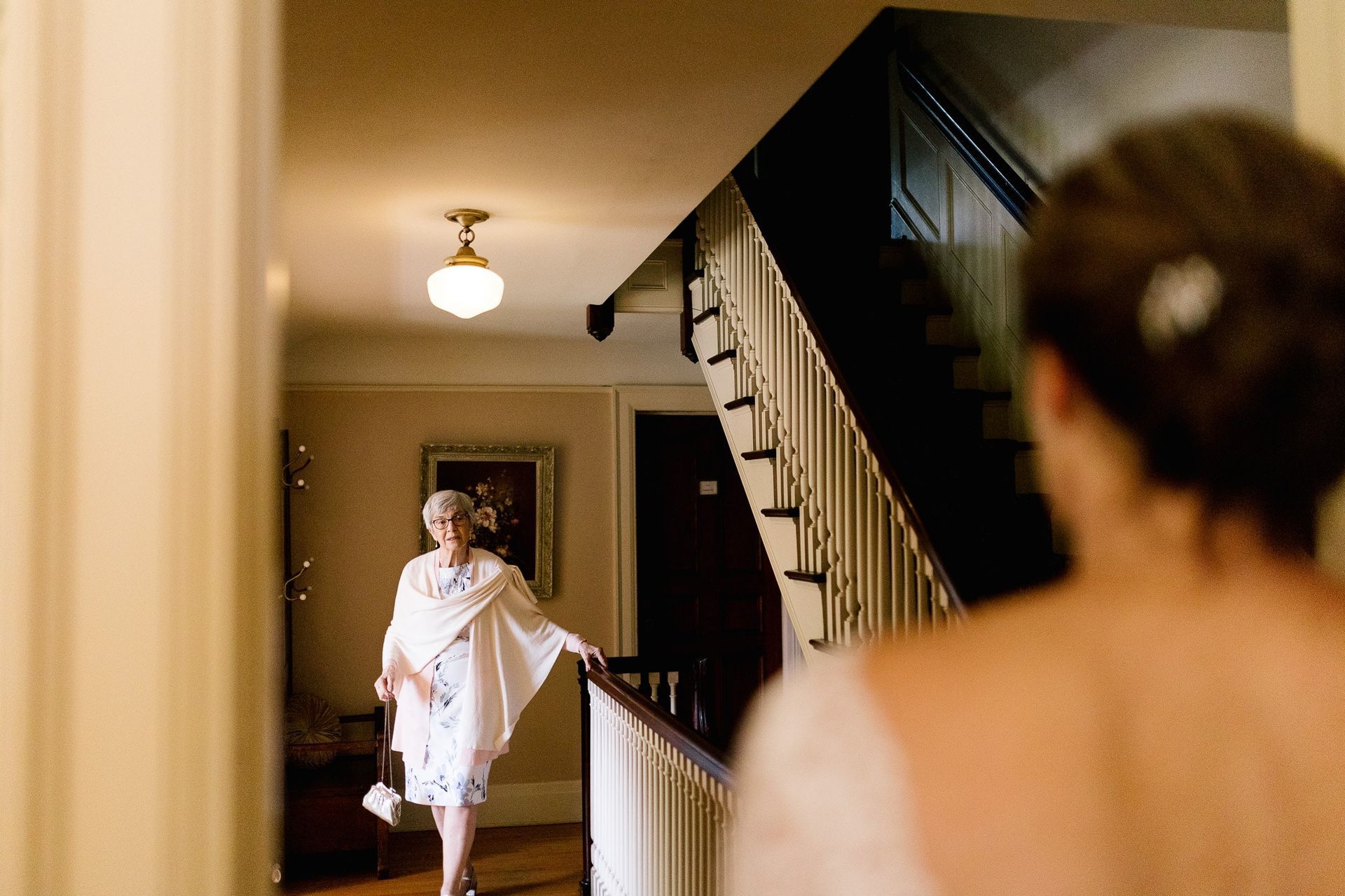 A woman in a white dress is walking down a set of stairs.