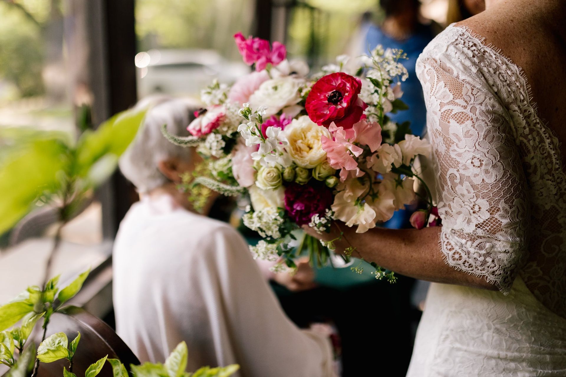 A bride in a wedding dress is holding a bouquet of flowers.