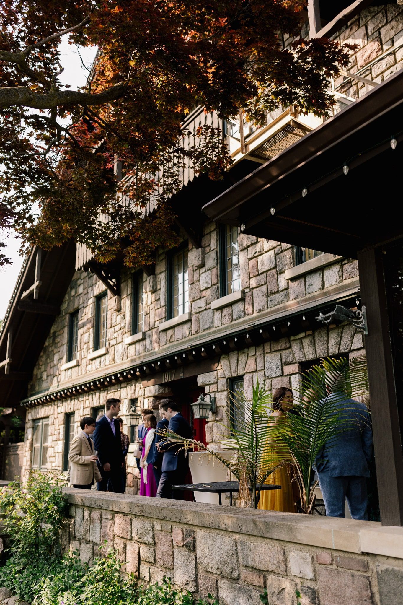 A group of people are standing outside of a large stone building.