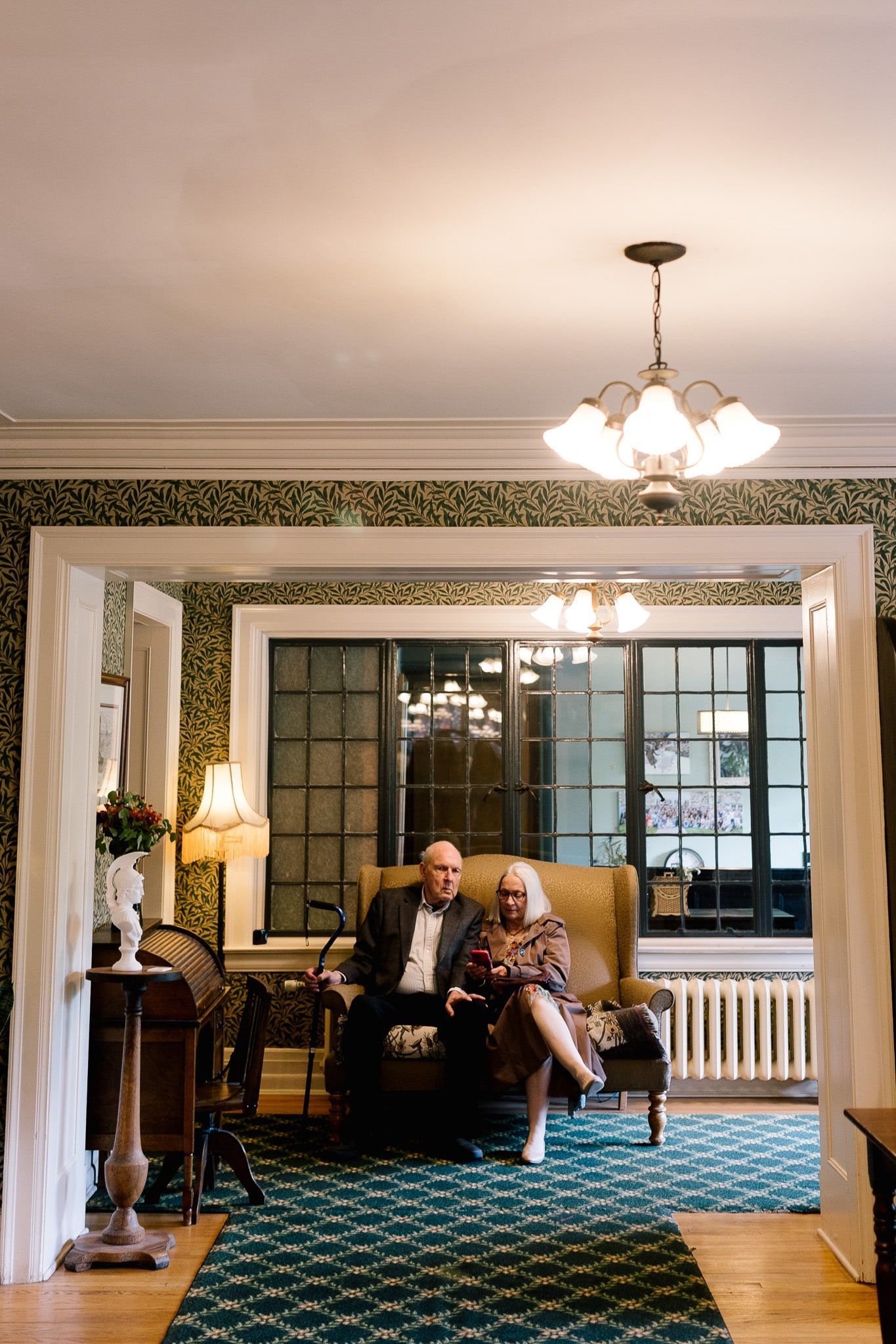 A man and a woman are sitting in chairs in a living room.