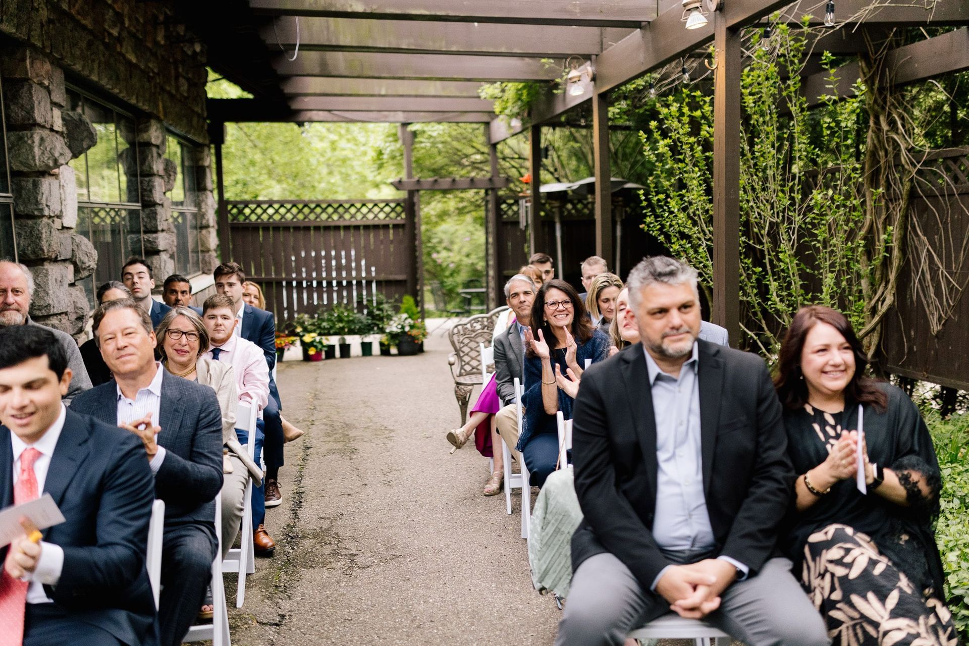 A group of people are sitting in chairs watching a wedding ceremony.