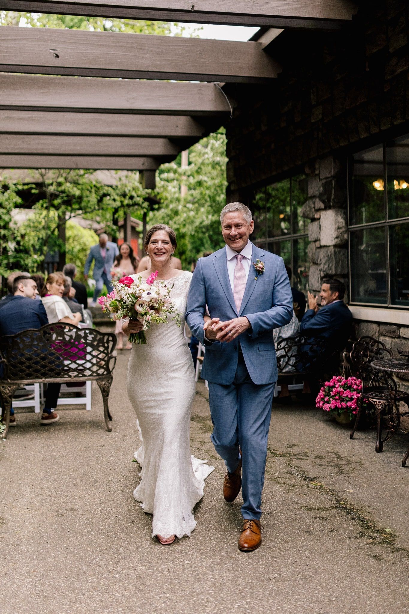 A bride and groom are walking down the aisle at their wedding.