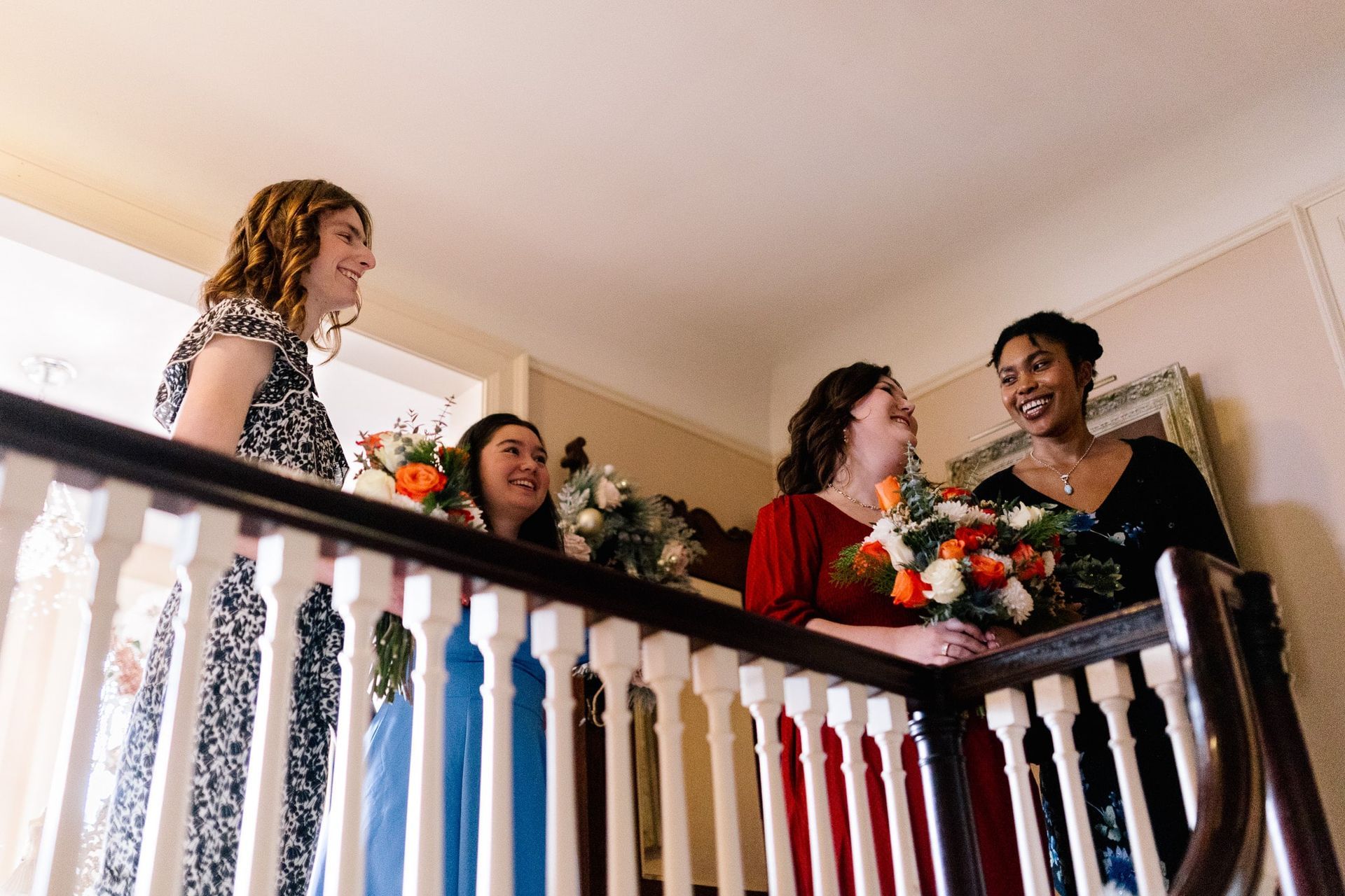 A group of women are standing on a staircase talking to each other.
