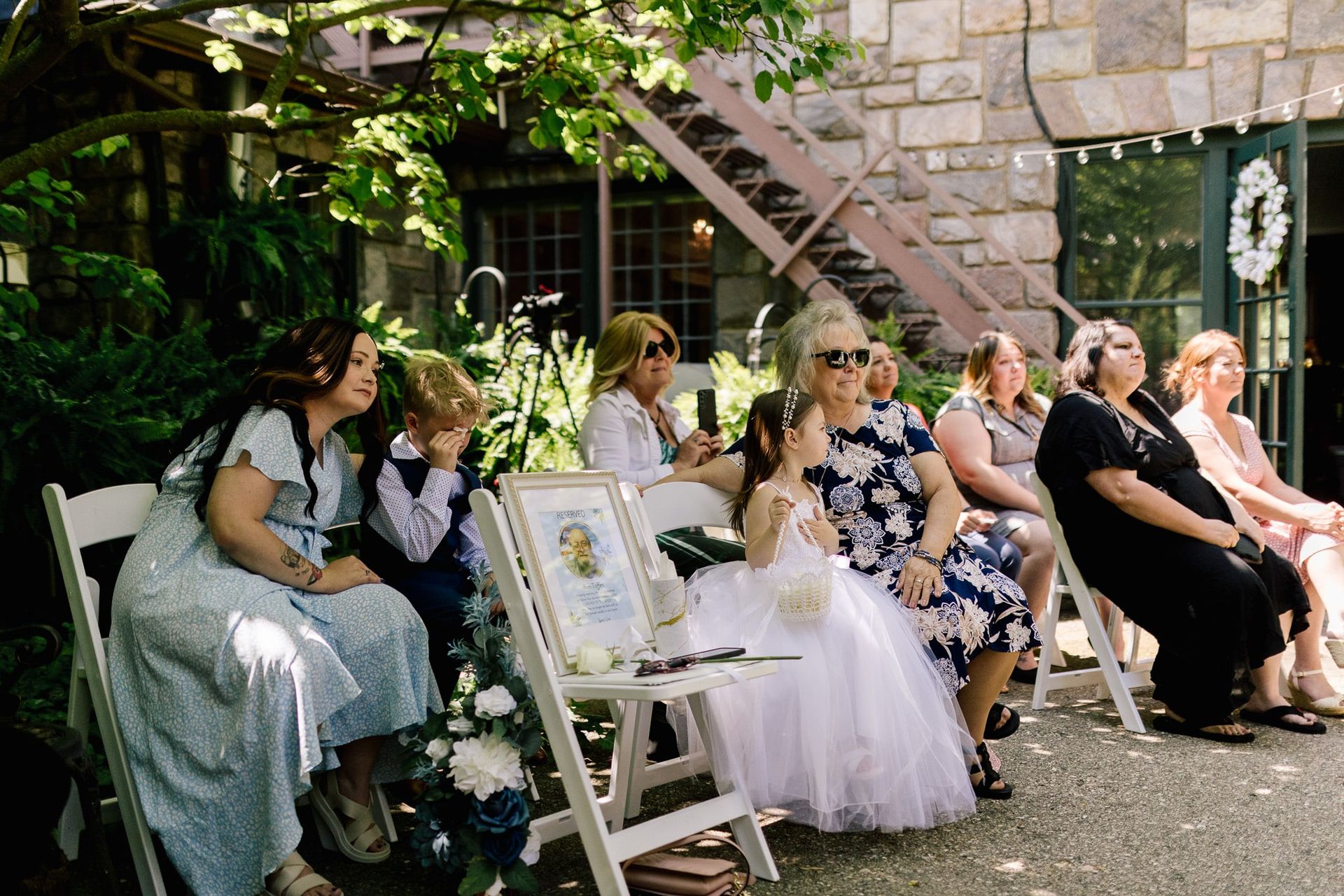 A group of people are sitting in chairs watching a wedding ceremony.