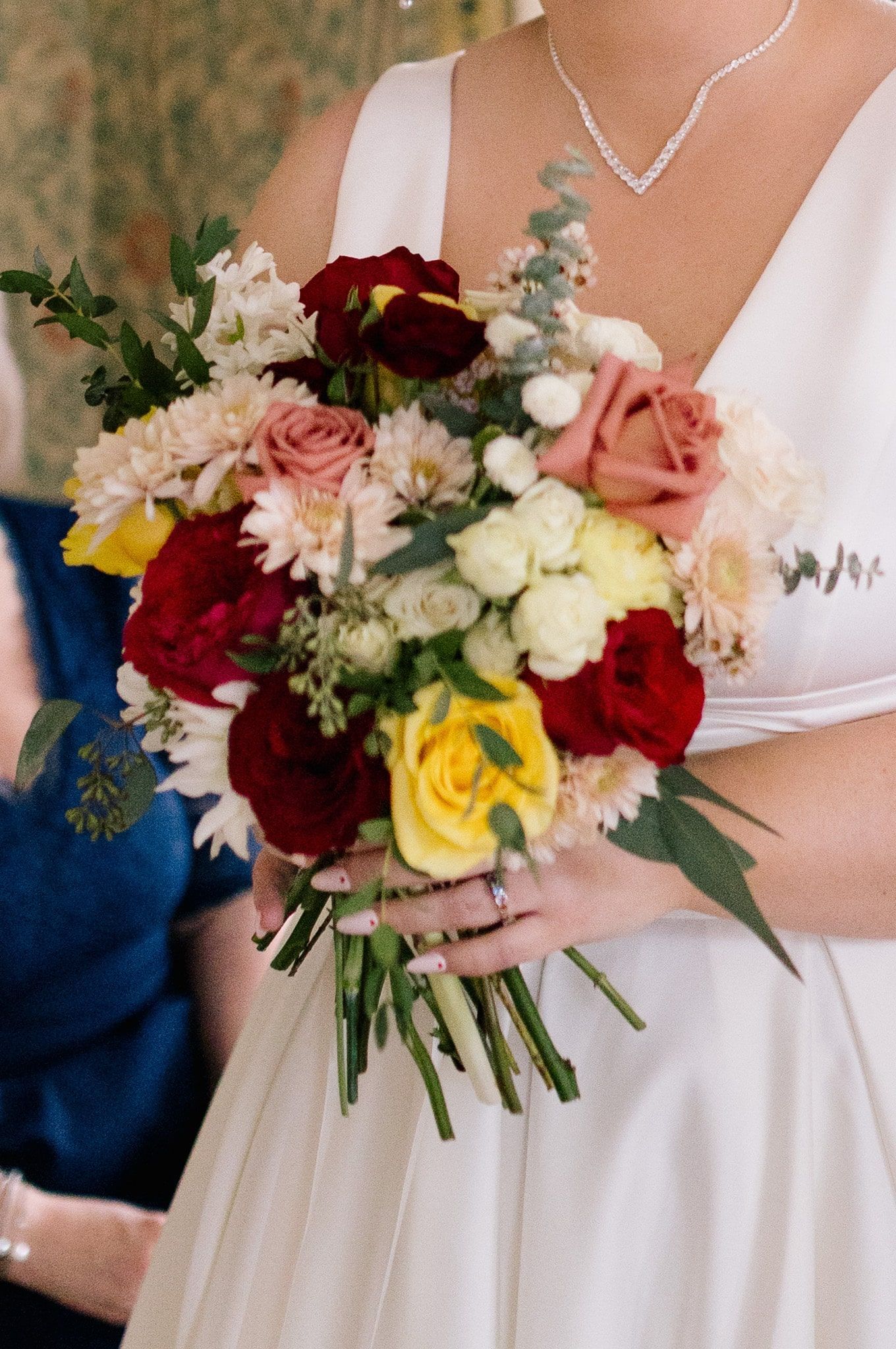 A woman in a white dress is holding a bouquet of flowers.