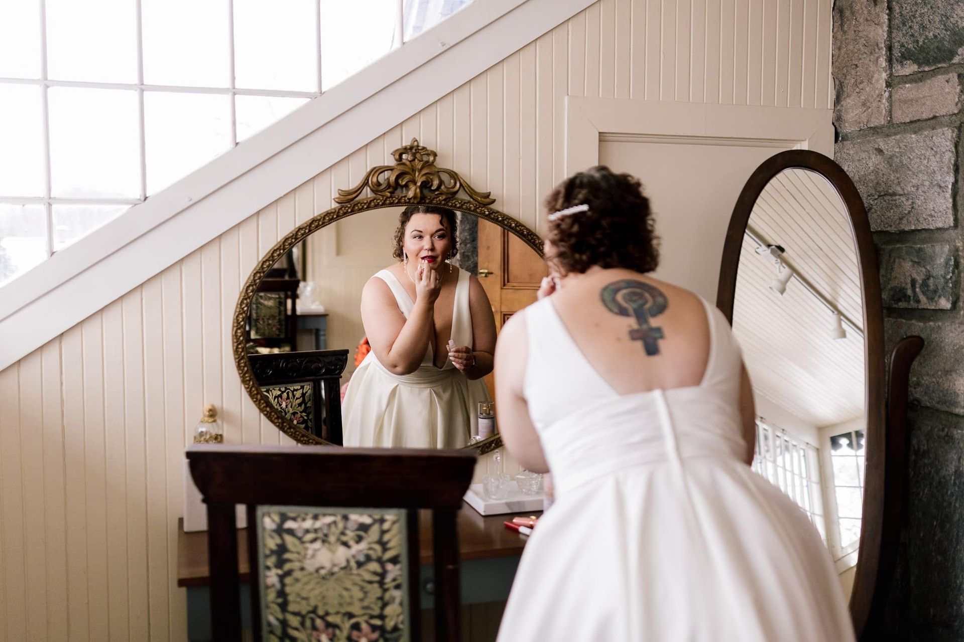 A woman in a wedding dress is looking at herself in a mirror.