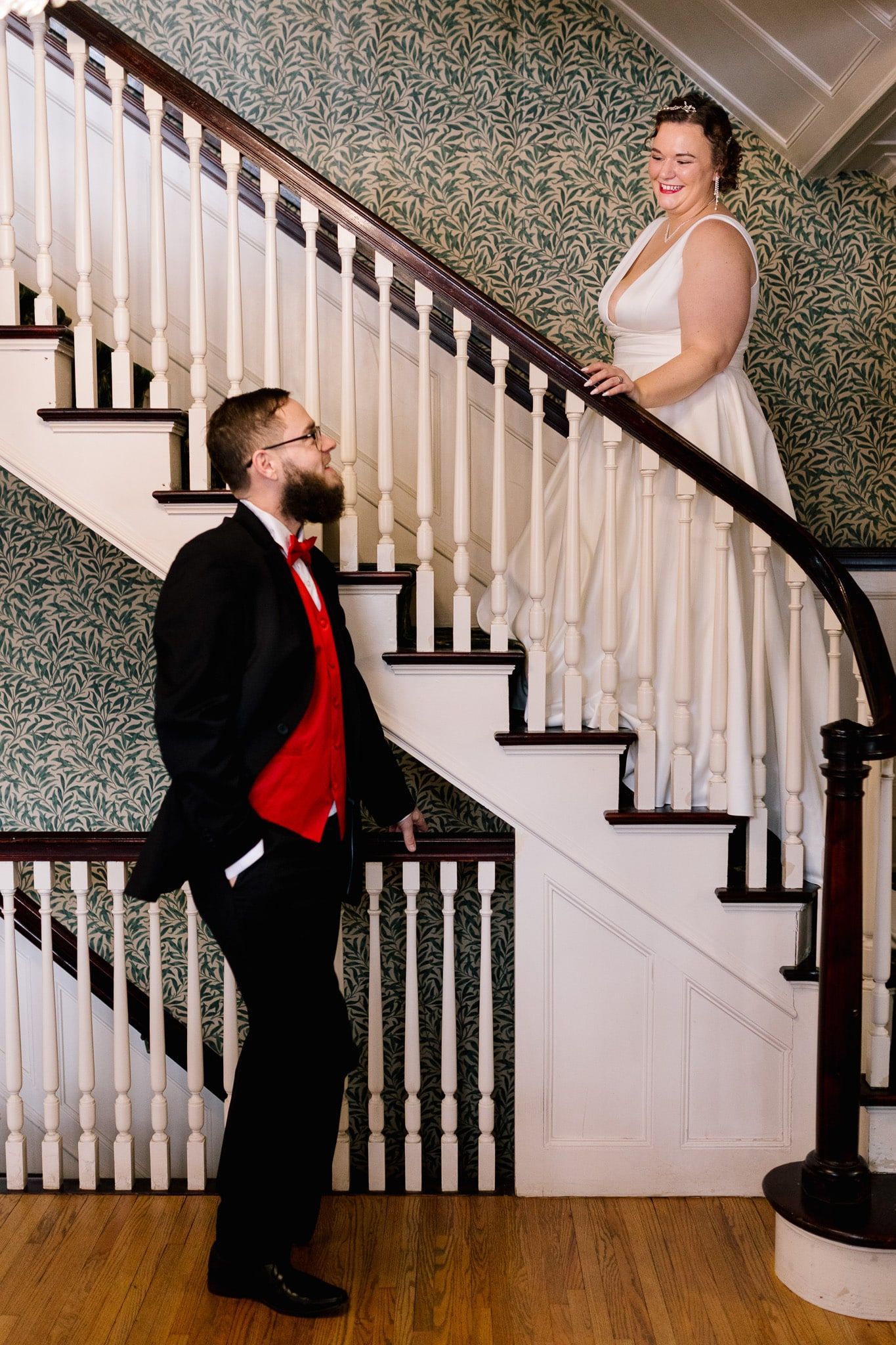A bride and groom are posing for a picture on a staircase.